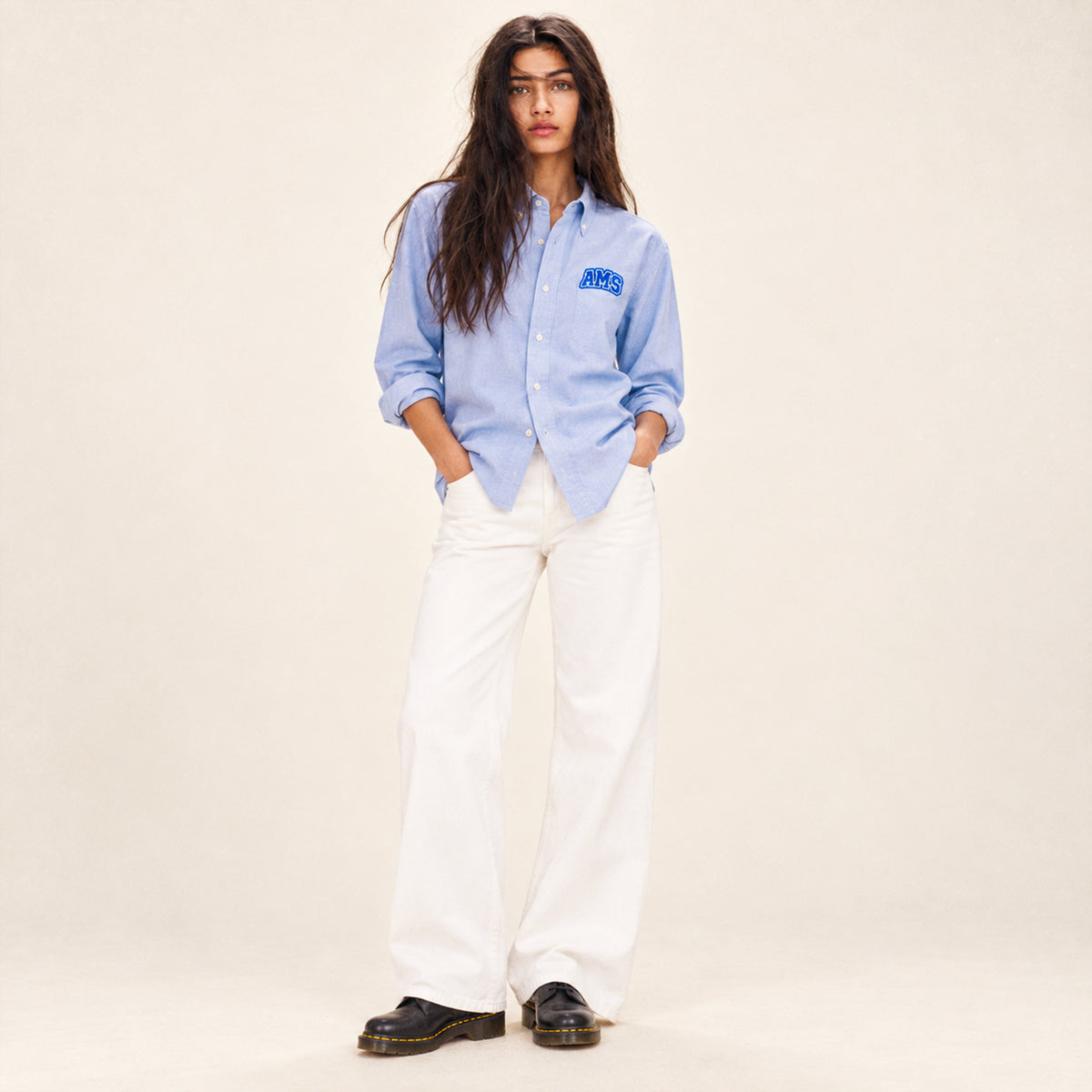 Chemise Oxford femme Beauséjour AMS bleu ciel en coton biologique, coupe élégante avec col classique, boutons blancs et patch AMS brodé sur la poitrine.