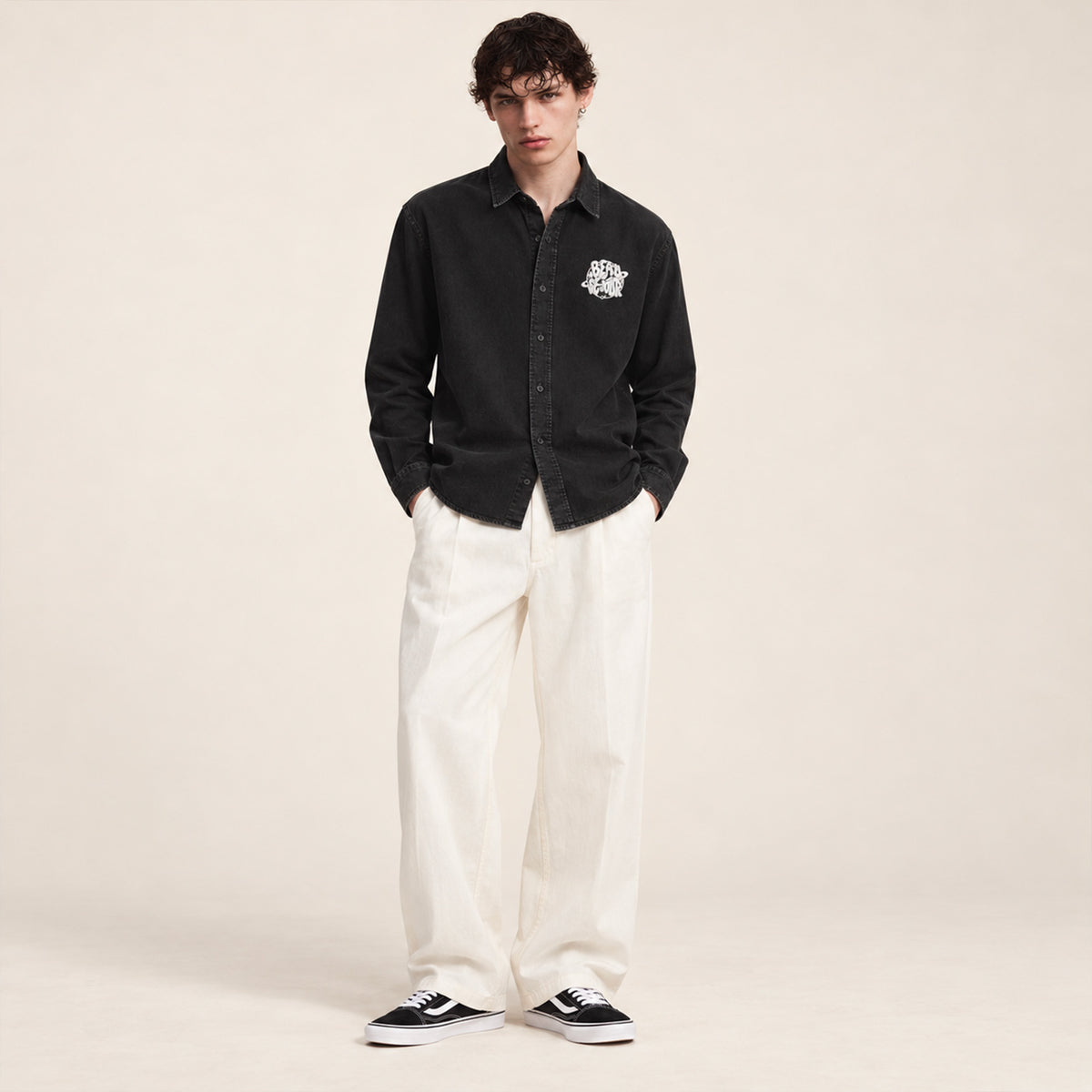 Chemise noire pour homme. Broderie planete sur le coeur. Vue de face.