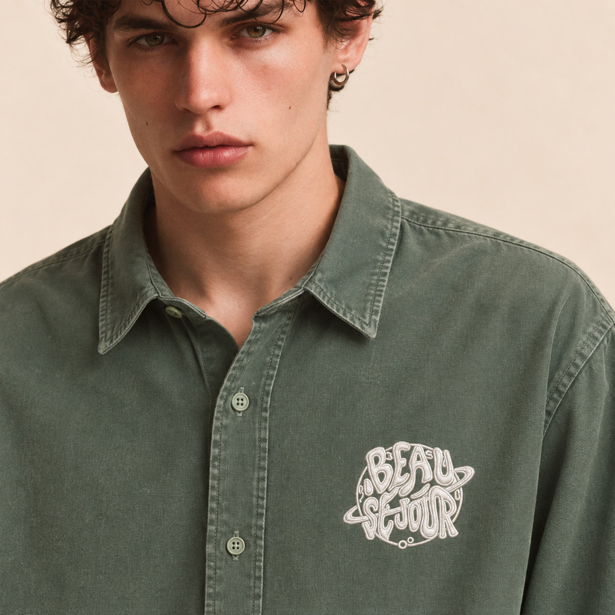 Chemise verte pour homme. Broderie planete sur le coeur. Vue de face zoom broderie.