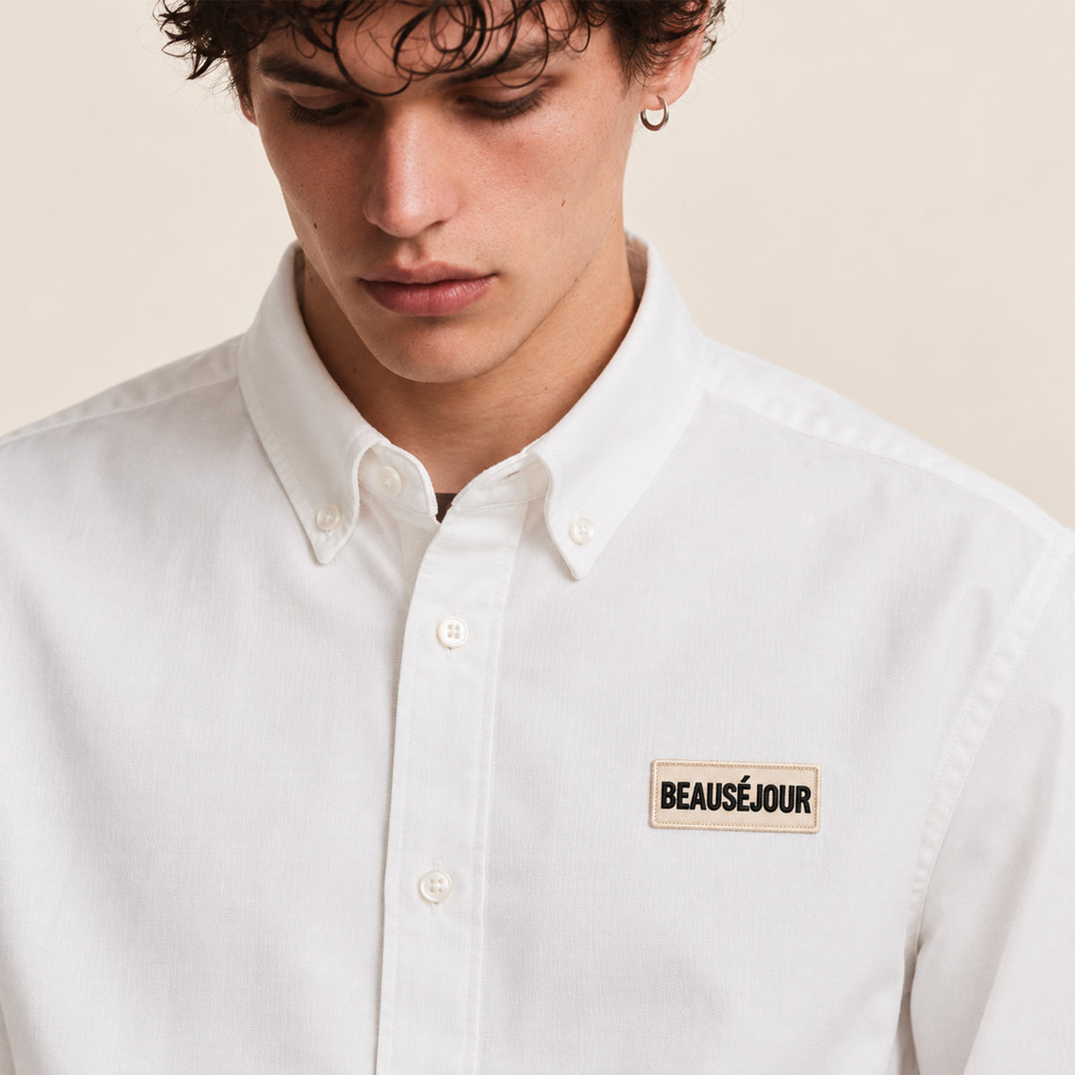 Chemise oxford pour homme blanche. Patch Beauséjour brodé sur le coeur. Zoom patch.
