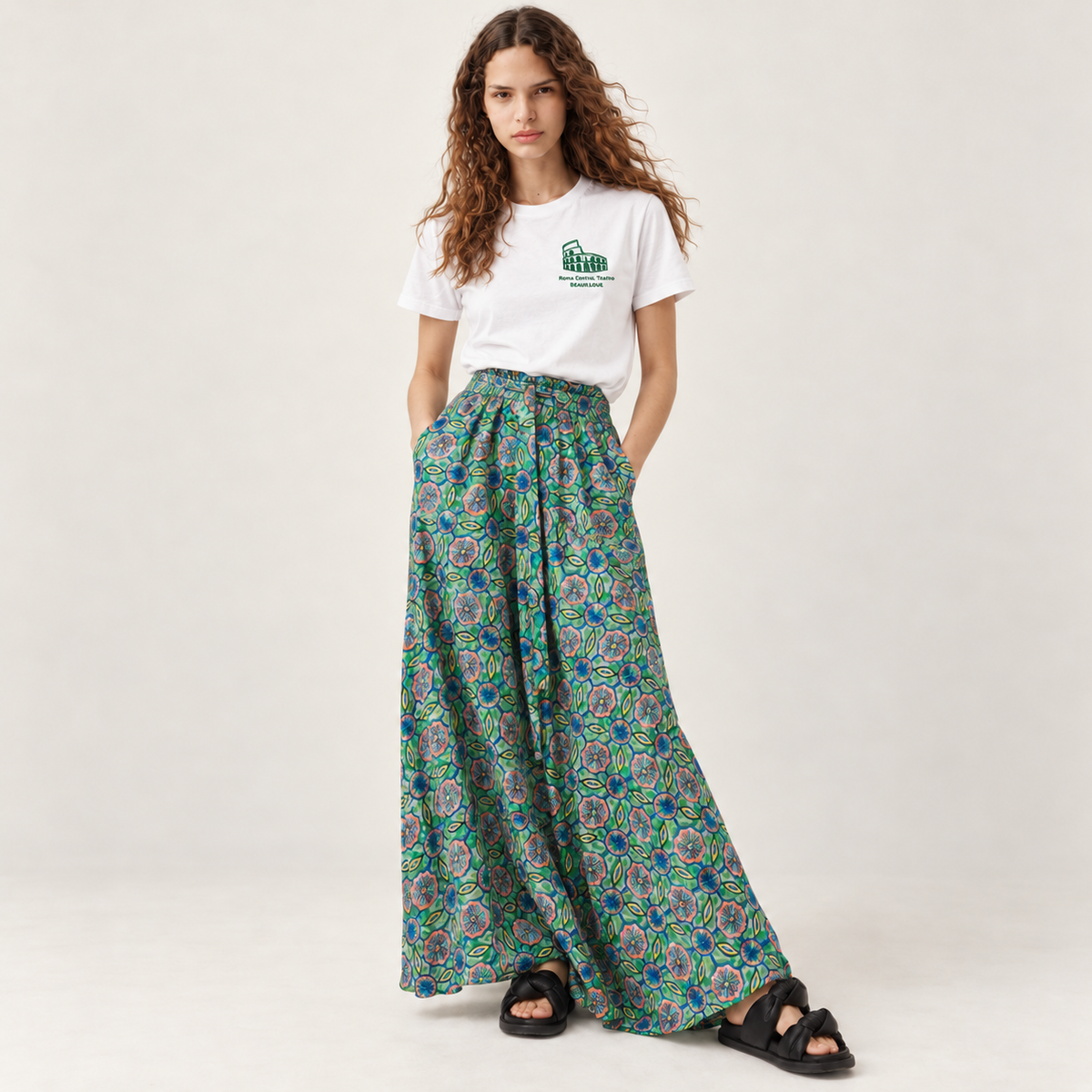 T-shirt Roma senza tempo Beauséjour porté avec une jupe longue imprimée verte, broderie verte du Colisée sur la poitrine.