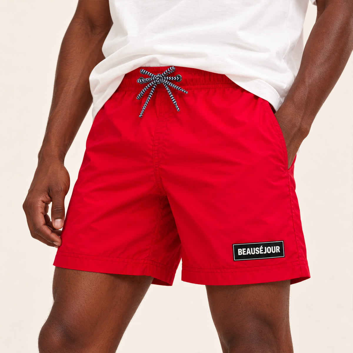 Maillot de bain rouge pour homme. Patch Beauséjour en caoutchouc signature sur la cuisse. zoom patch.