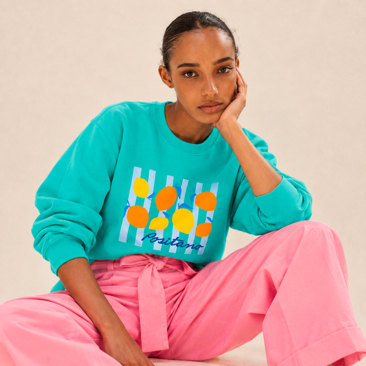 Femme portant un sweat col rond Positano turquoise avec motif citrons, Beauséjour. Coton bio.