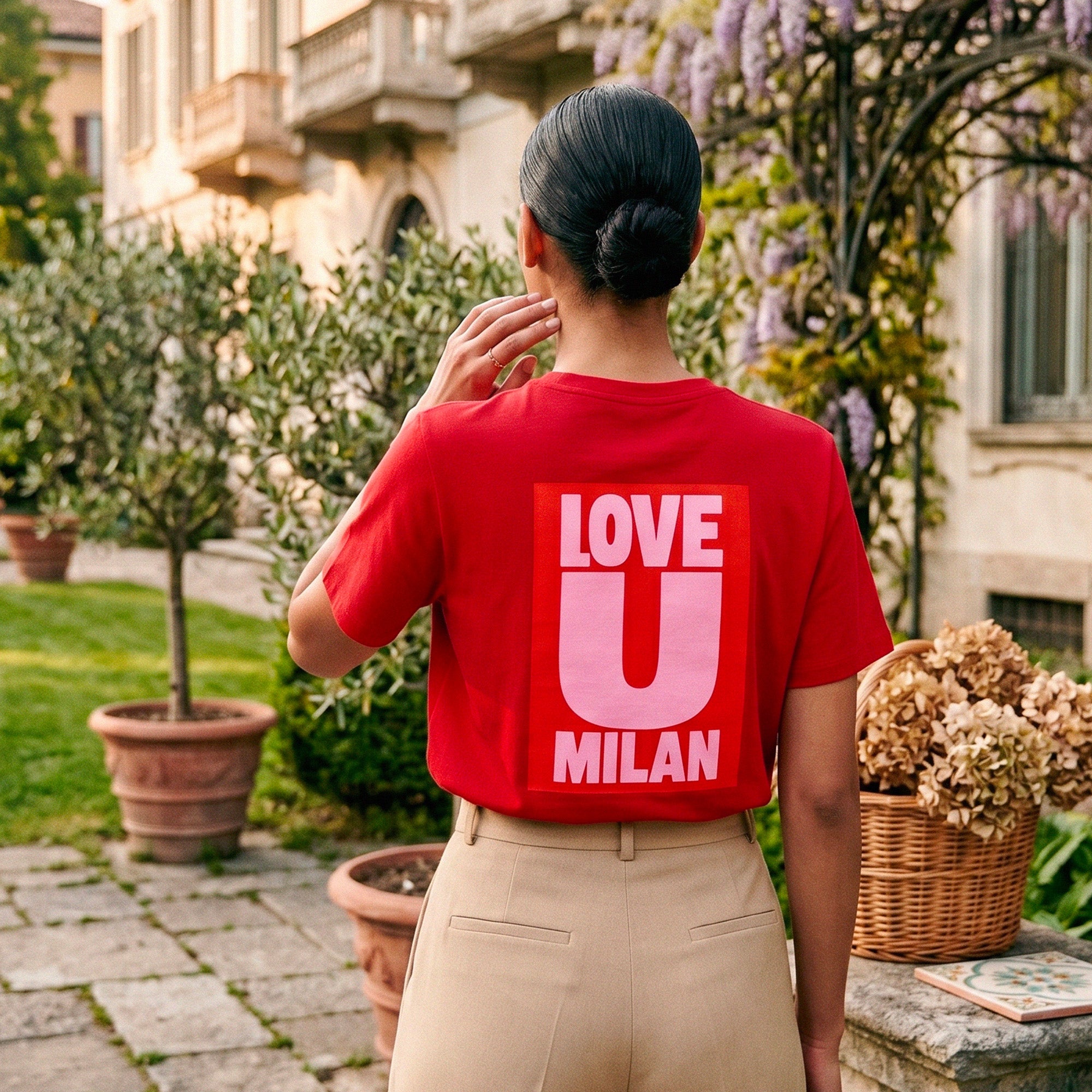 T-shirt rouge Beauséjour Milan "Love U Milan", imprimé graphique blanc au dos, coupe moderne femme, style casual chic inspiré de l’Italie, porté en extérieur.