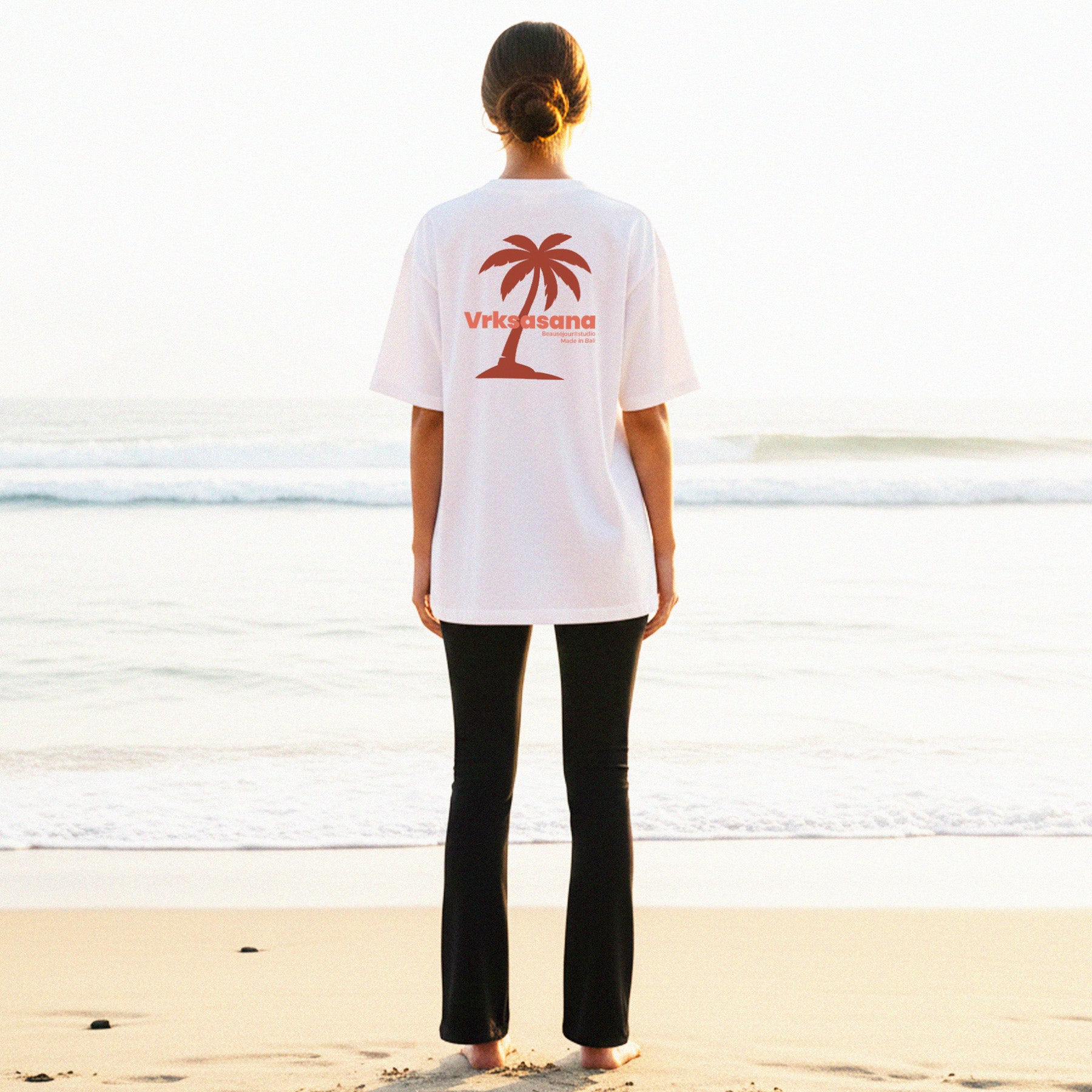 Femme de dos à la plage à Bali. Elle porte le tshirt en coton biologique Vrksasana. Parfait pour les amoureux du yoga.TShirt femme - TShirt pour femme - TShirt Lifestyle - TShirt yoga pour femme