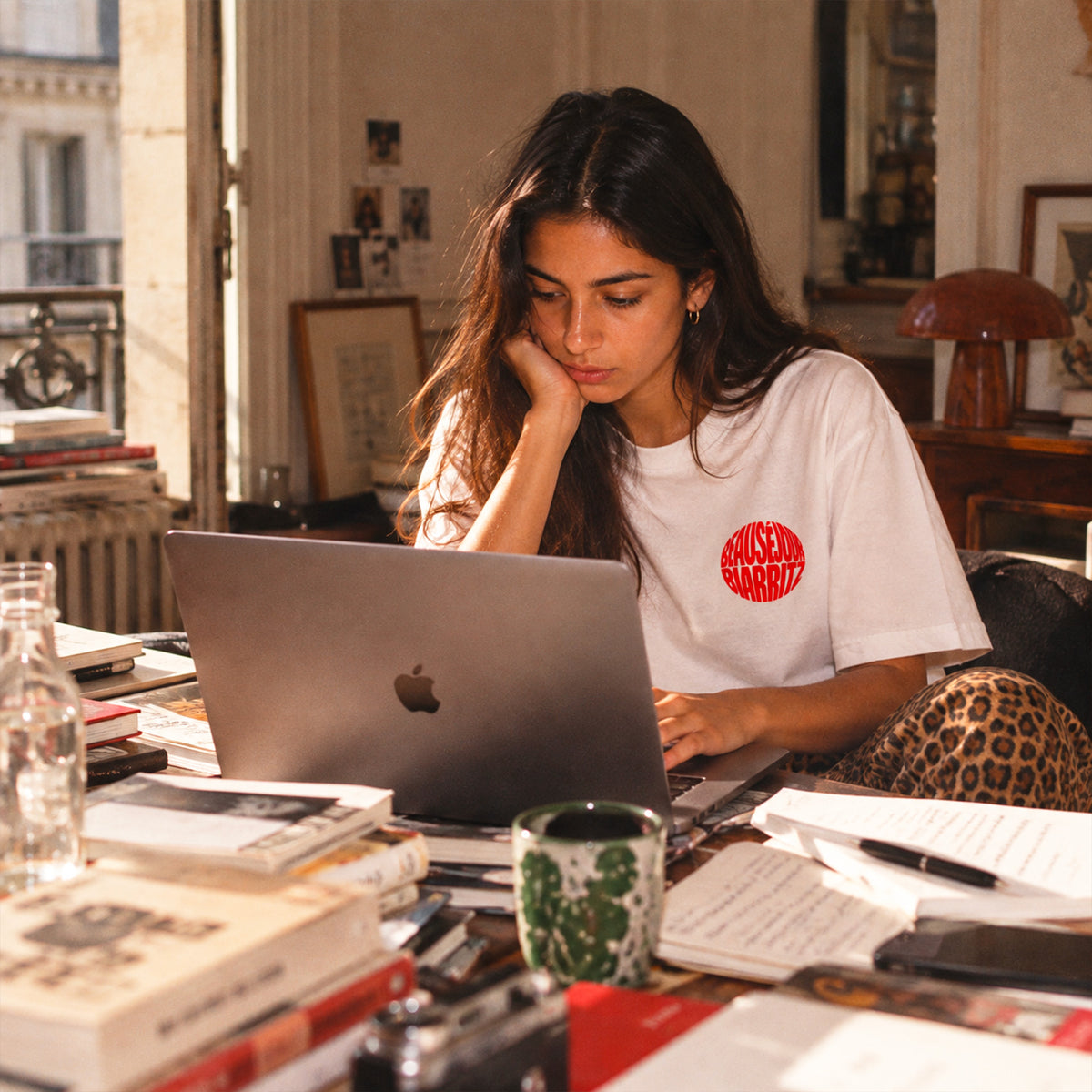 T-shirt blanc Beauséjour Bonsoir Biarritz porté par une femme, logo rouge sur la poitrine, coupe classique unisexe et style casual inspiré de la côte basque.