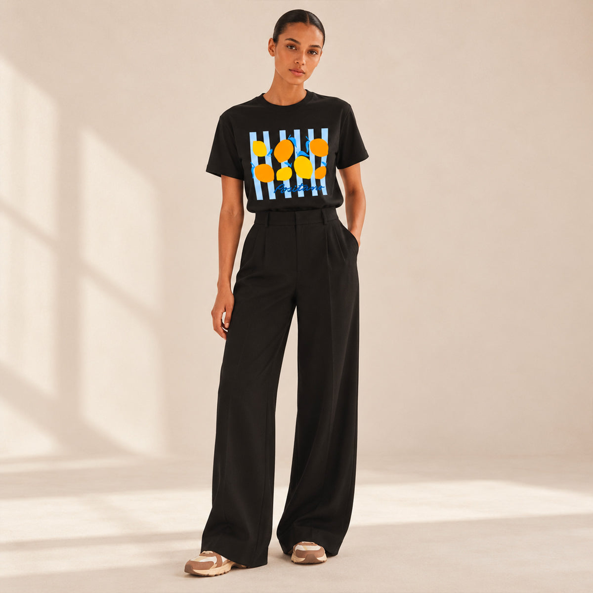 Femme portant un t-shirt noir Positano Beauséjour avec motif citron.