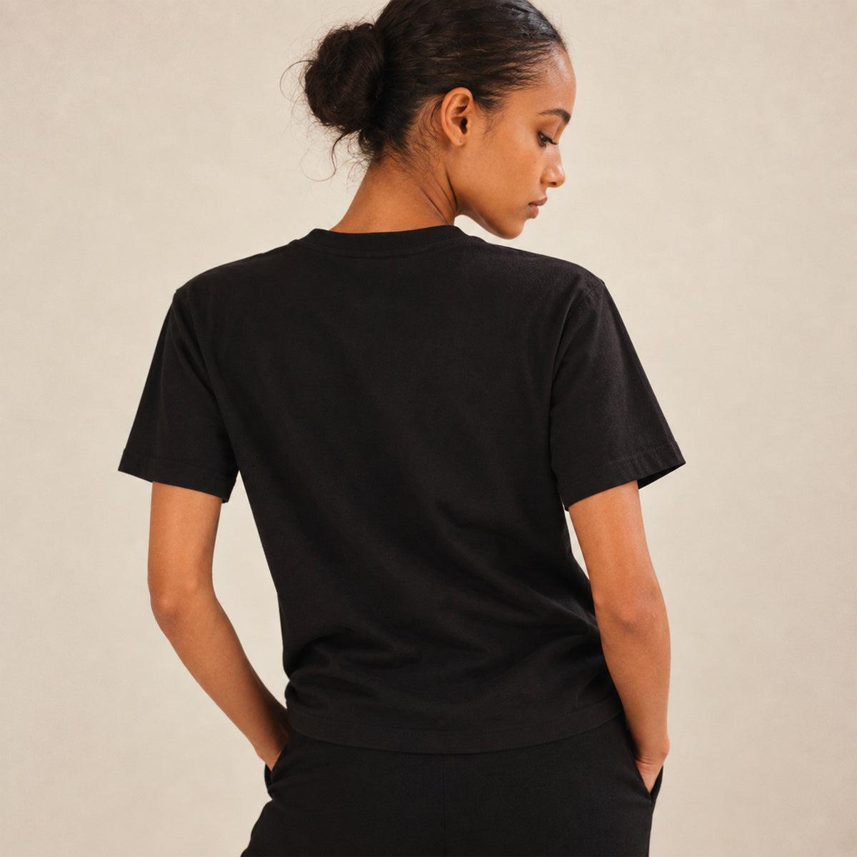Femme portant un t-shirt noir Positano Beauséjour avec motif citron, vue de dos