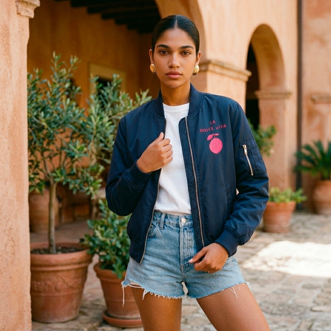 Look estival femme avec bomber bleu marine et short sur la cote italienne