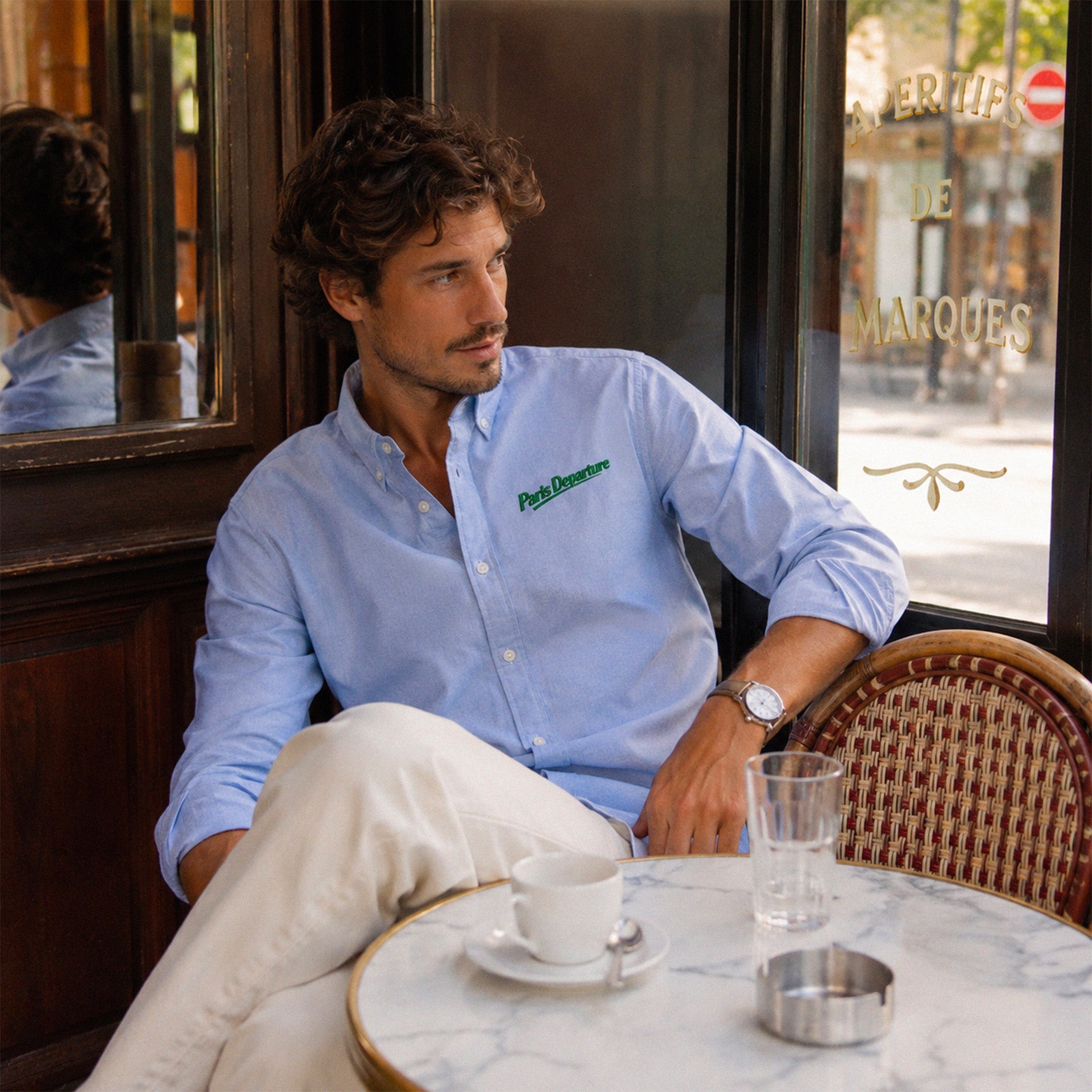 Chemise Oxford Paris Departure Beauséjour Orient Express, coloris bleu Oxford, 100% coton biologique Oxford, broderie Paris Departure verte côté cœur inspirée des uniformes de voyage anciens, détail de la broderie.
