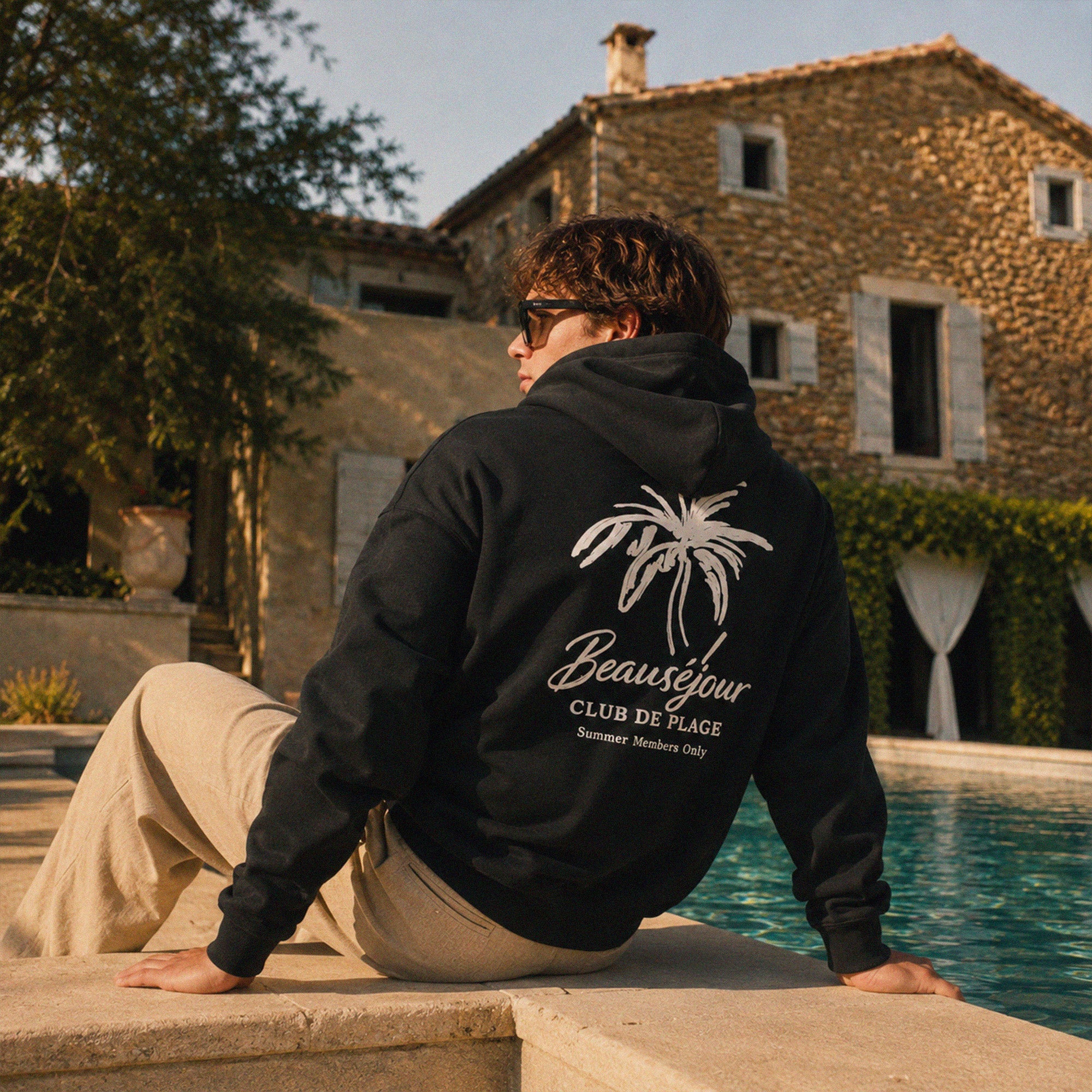 Hoodie homme noir Beauséjour avec logo blanc sur la poitrine, coupe décontractée et style resort wear premium.