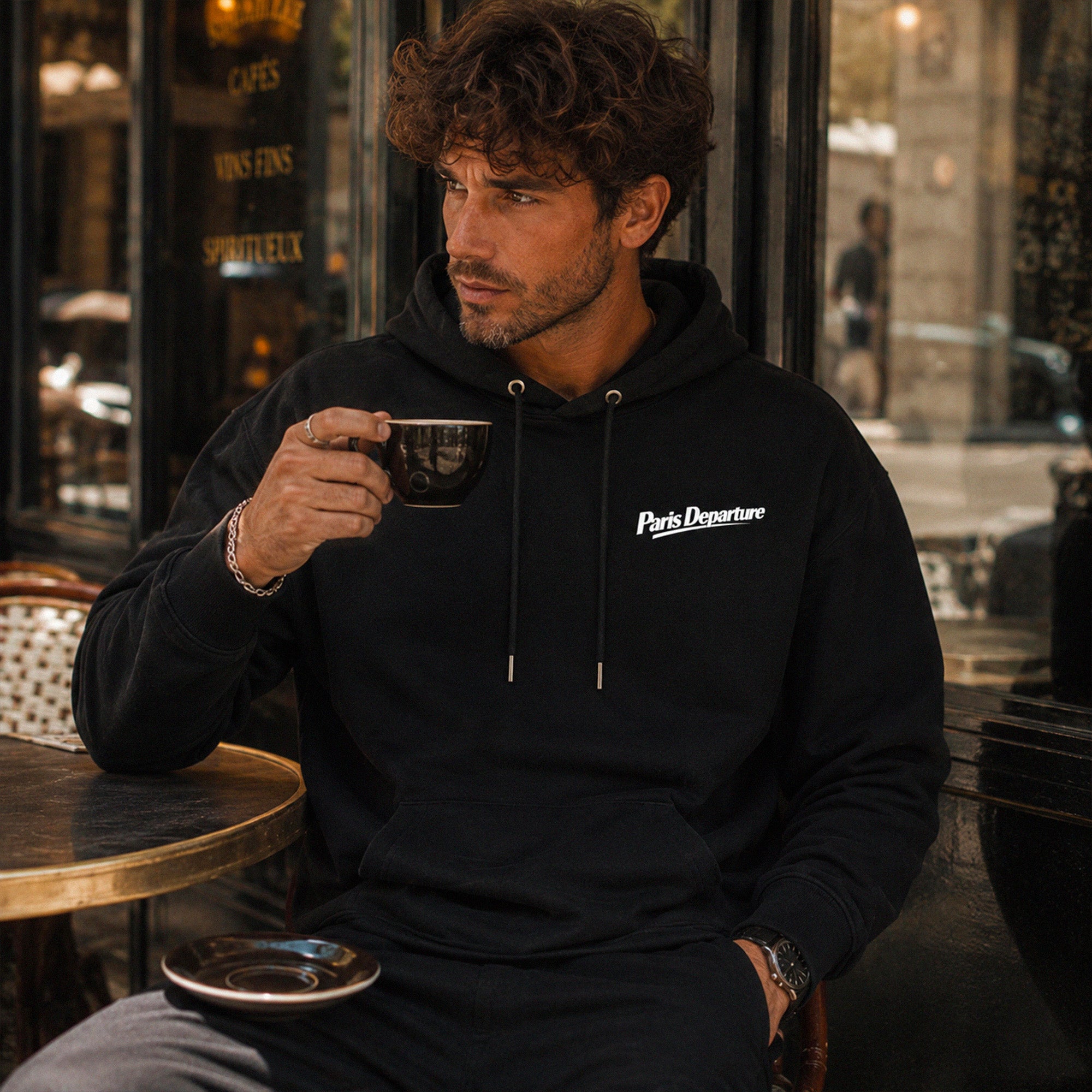 Hoodie Paris Departure Beauséjour Orient Express, coloris noir profond, 100% coton biologique molleton brossé, imprimé Paris Departure côté cœur et marquage dos inspiré des compagnies de voyage anciennes, vue de dos.