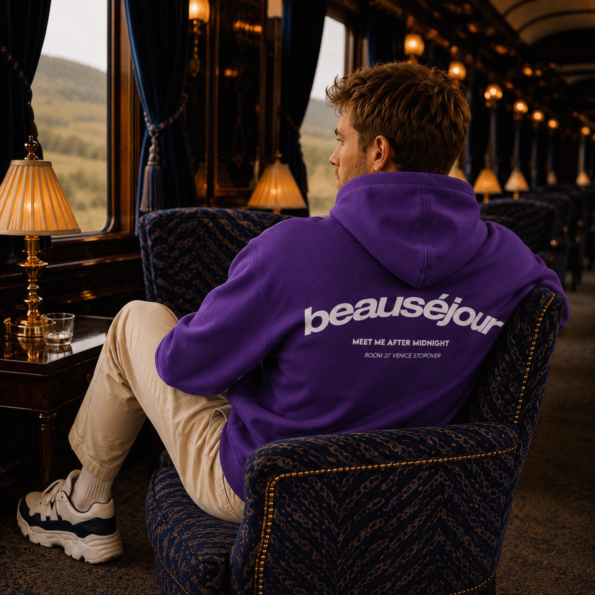 Hoodie Room 27 Venice Beauséjour Orient Express, coloris violet profond, logo poitrine minimaliste et grand imprimé dos "Beauséjour — Meet Me After Midnight — Room 27 Venice Stopover", capuche ajustable et poche kangourou, vue de face.