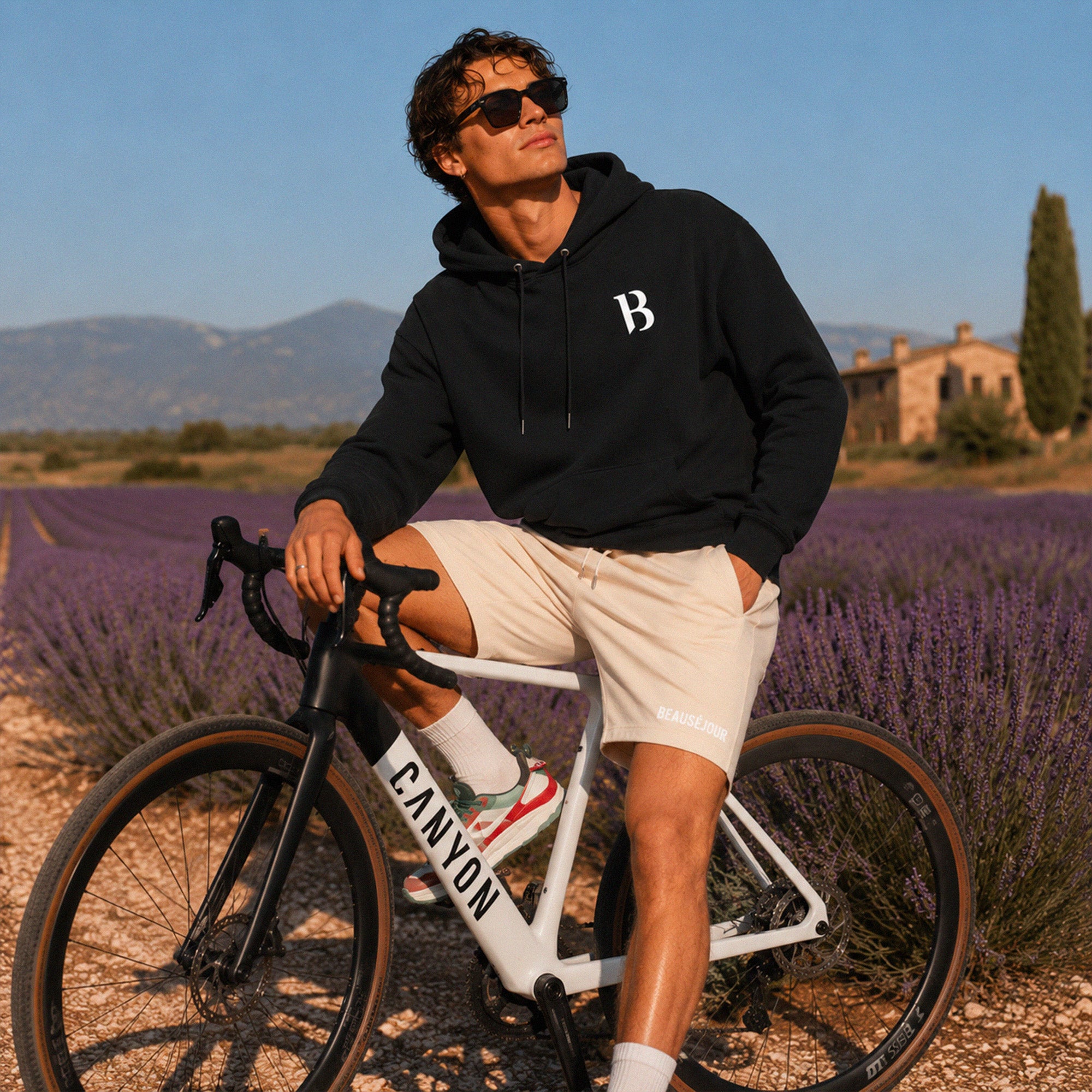 Hoodie Signature B Beauséjour, coloris noir, molleton brossé 100% coton biologique Ring Spun Combed, logo B Beauséjour brodé poitrine, capuche doublée et poche kangourou, vue de dos.