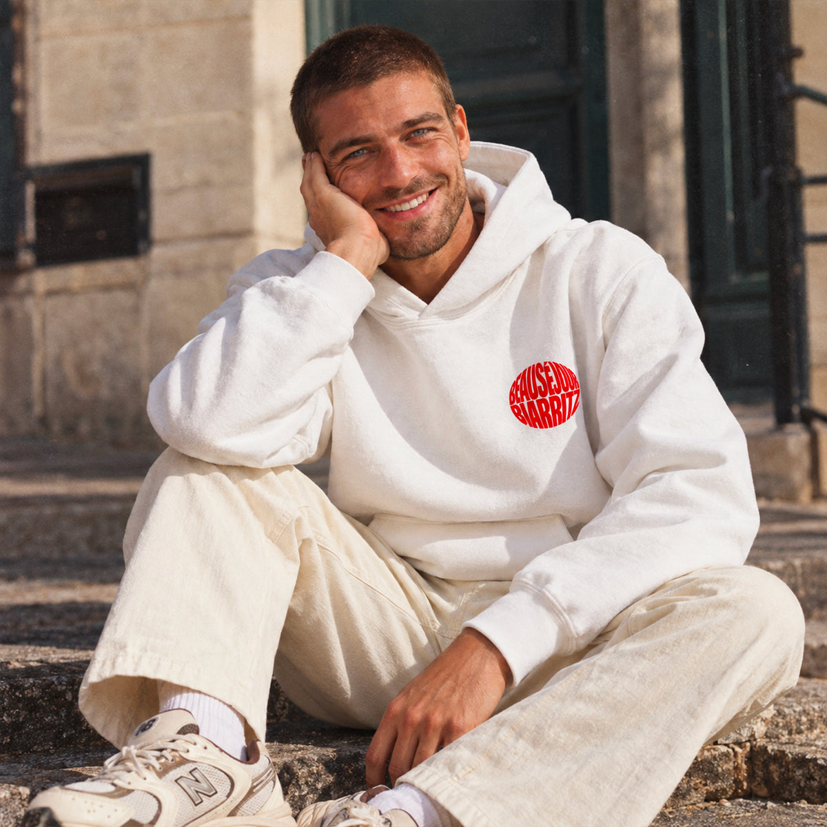 homme portant un hoodie blanc bonsoir biarritz. vue de face.