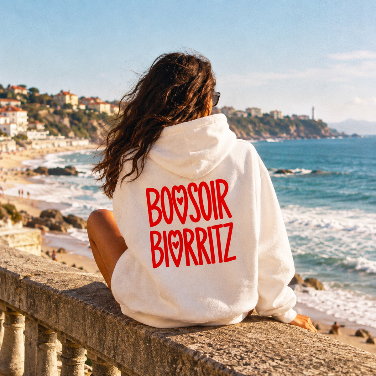 Hoodie Bonsoir Biarritz blanc, porté par une femme.