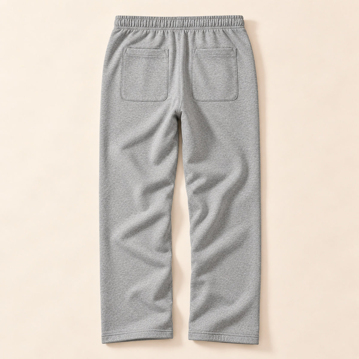 Jogging gris femme Beauséjour, coupe droite et ample, taille élastique, poches latérales et patch brodé écru avec logo noir sur la cuisse. vue de dos.