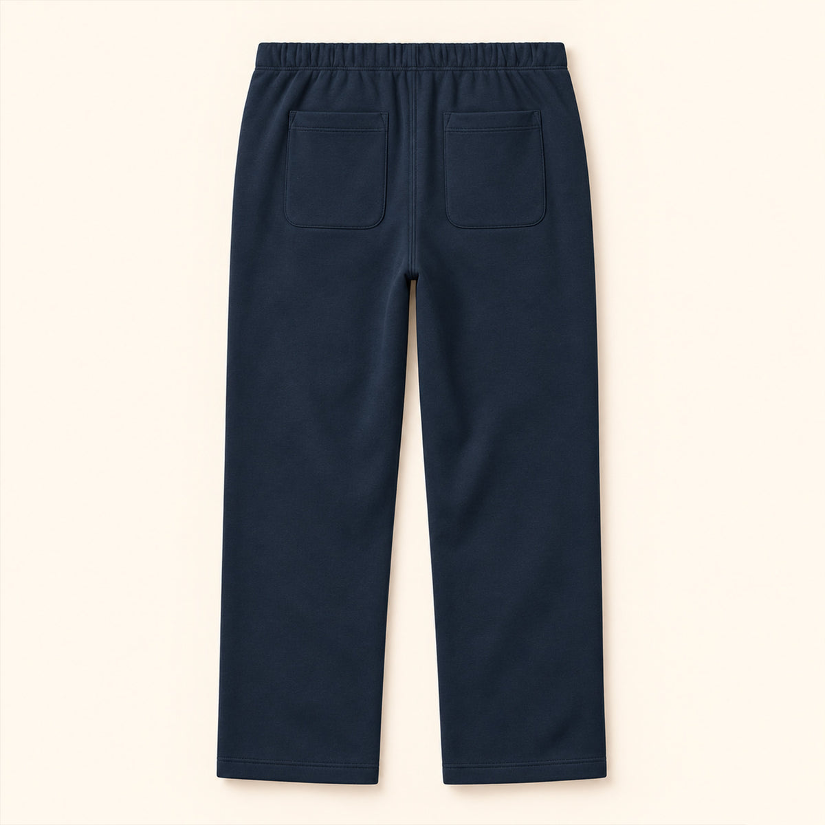 Jogging bleu marine femme Beauséjour, coupe droite et ample, taille élastique, poches latérales et patch brodé écru avec logo noir sur la cuisse. vue de dos.