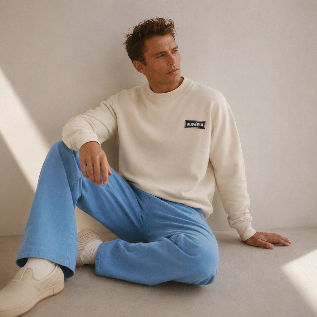 Sweatshirt basique Beauséjour® col rond coloris crème, coton biologique 350g, patch Beauséjour noir sur blanc en poitrine, vue de face.