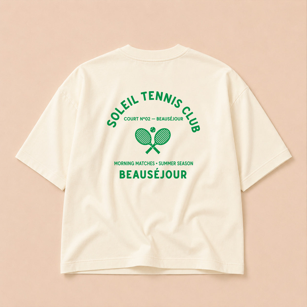 Packshot du t-shirt boxy crème Tennis Club Beauséjour, vue de dos, grand imprimé raquettes croisées et inscription Tennis Club.
