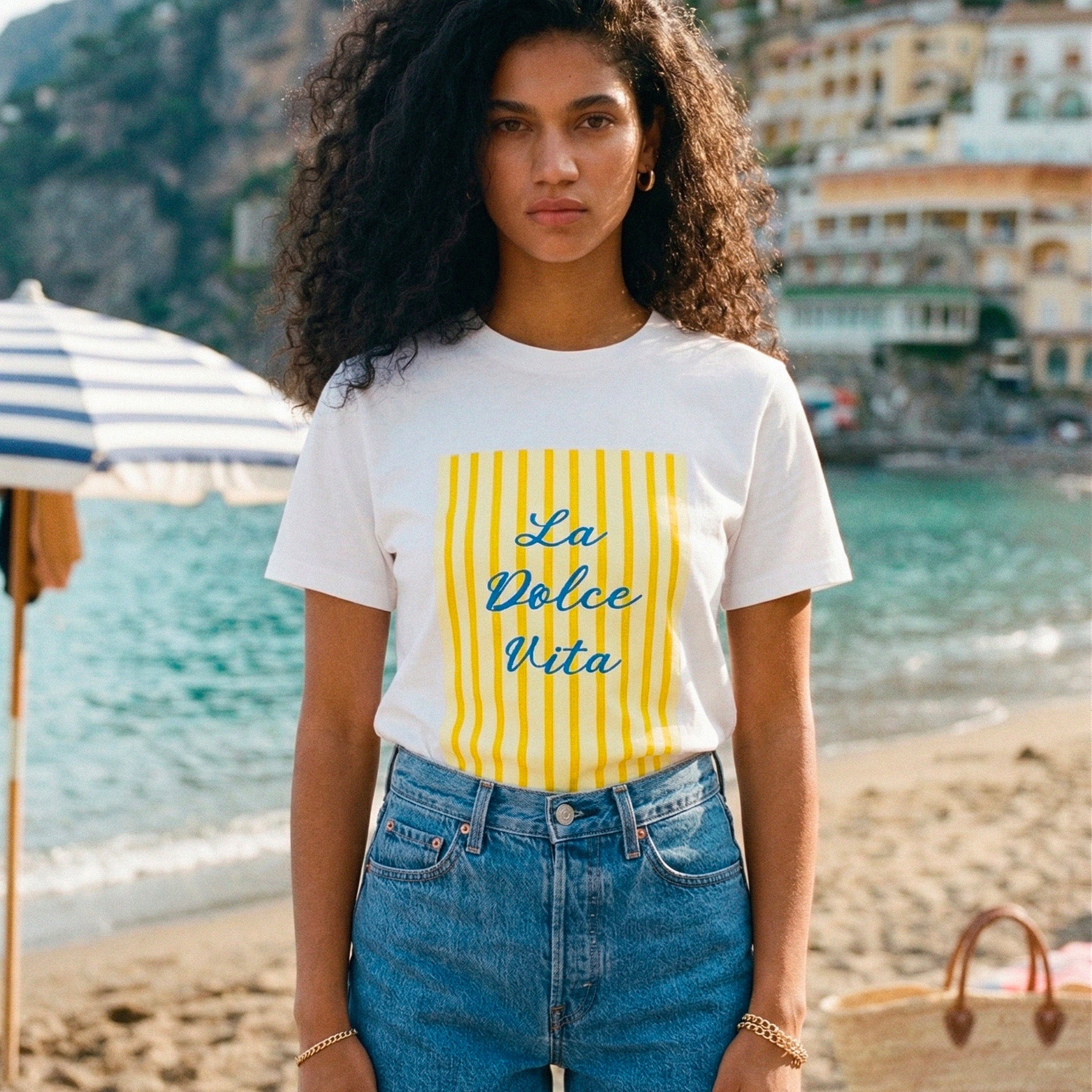 Femme portant un tshirt graphique La Dolce Vita en terrasse face a la mer