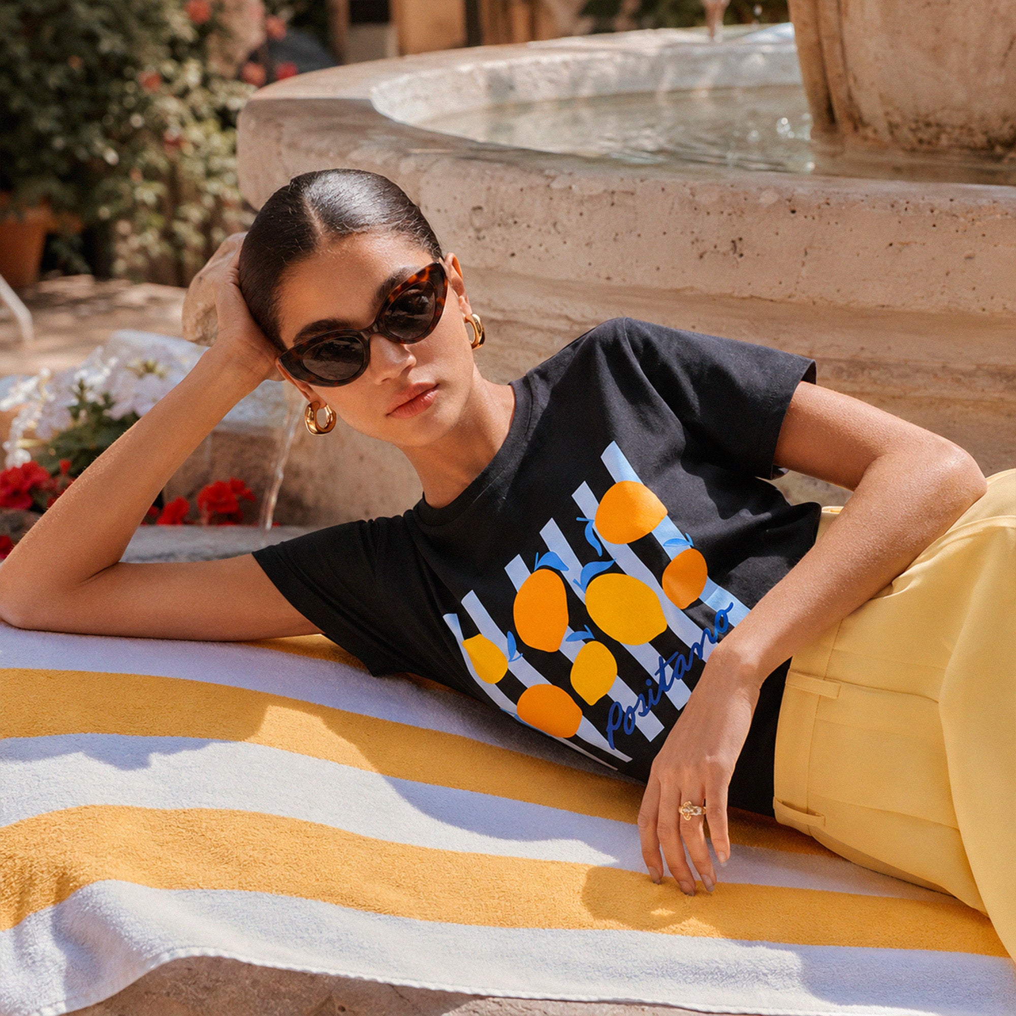 Femme portant un tshirt noir Positano avec motif citron