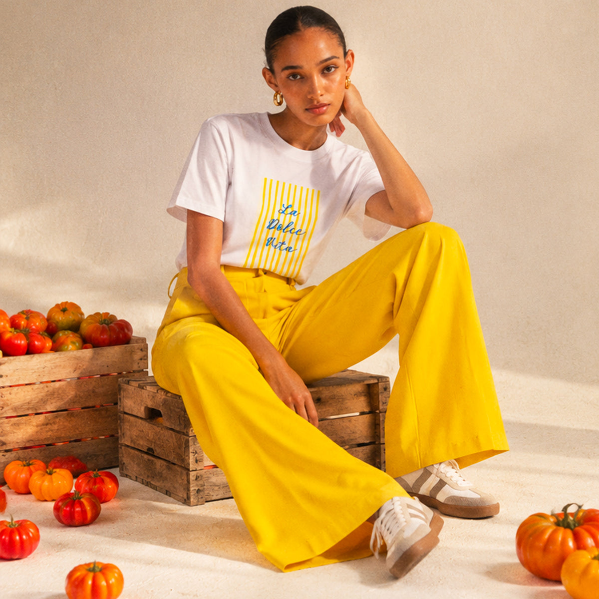 Femme portant un t-shirt blanc La Dolce Vita jaune Beauséjour en coton biologique.