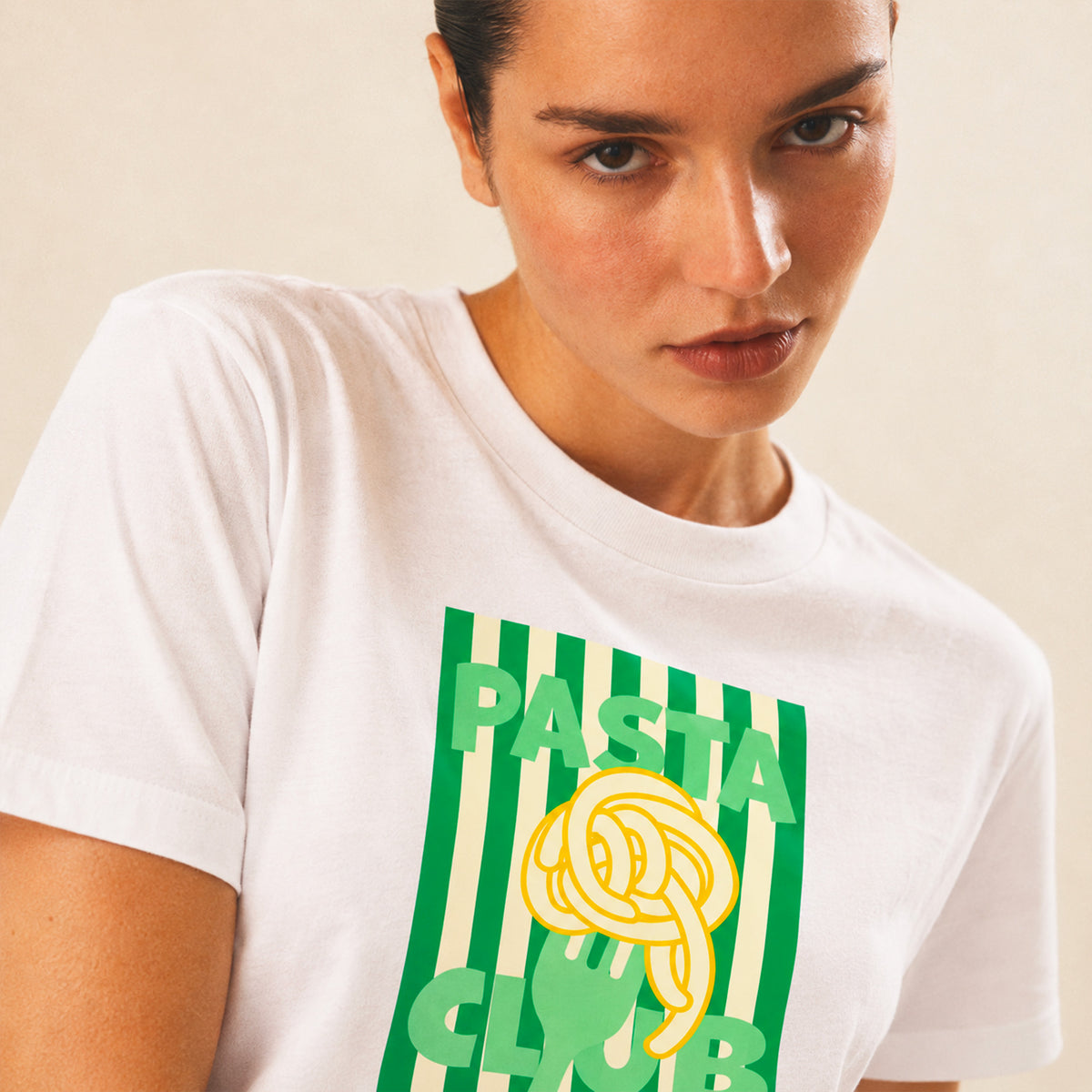 Femme portant un t-shirt blanc Pasta Club avec imprimé vert, Beauséjour. 100% coton biologique.
