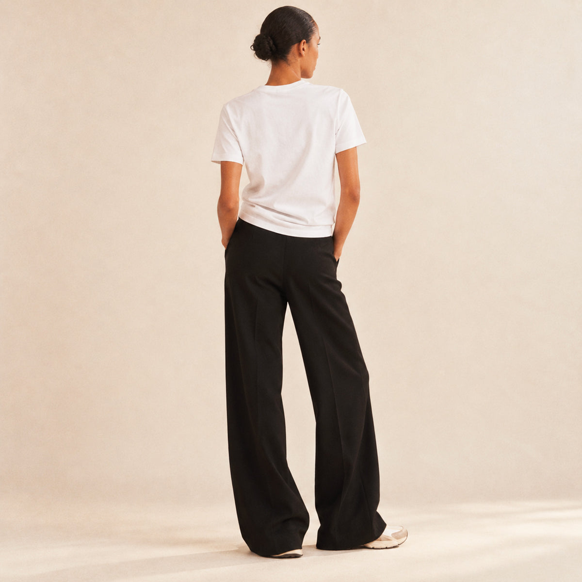 Femme portant un t-shirt blanc Respira la Vita Beauséjour, imprimé orange, vue de dos.