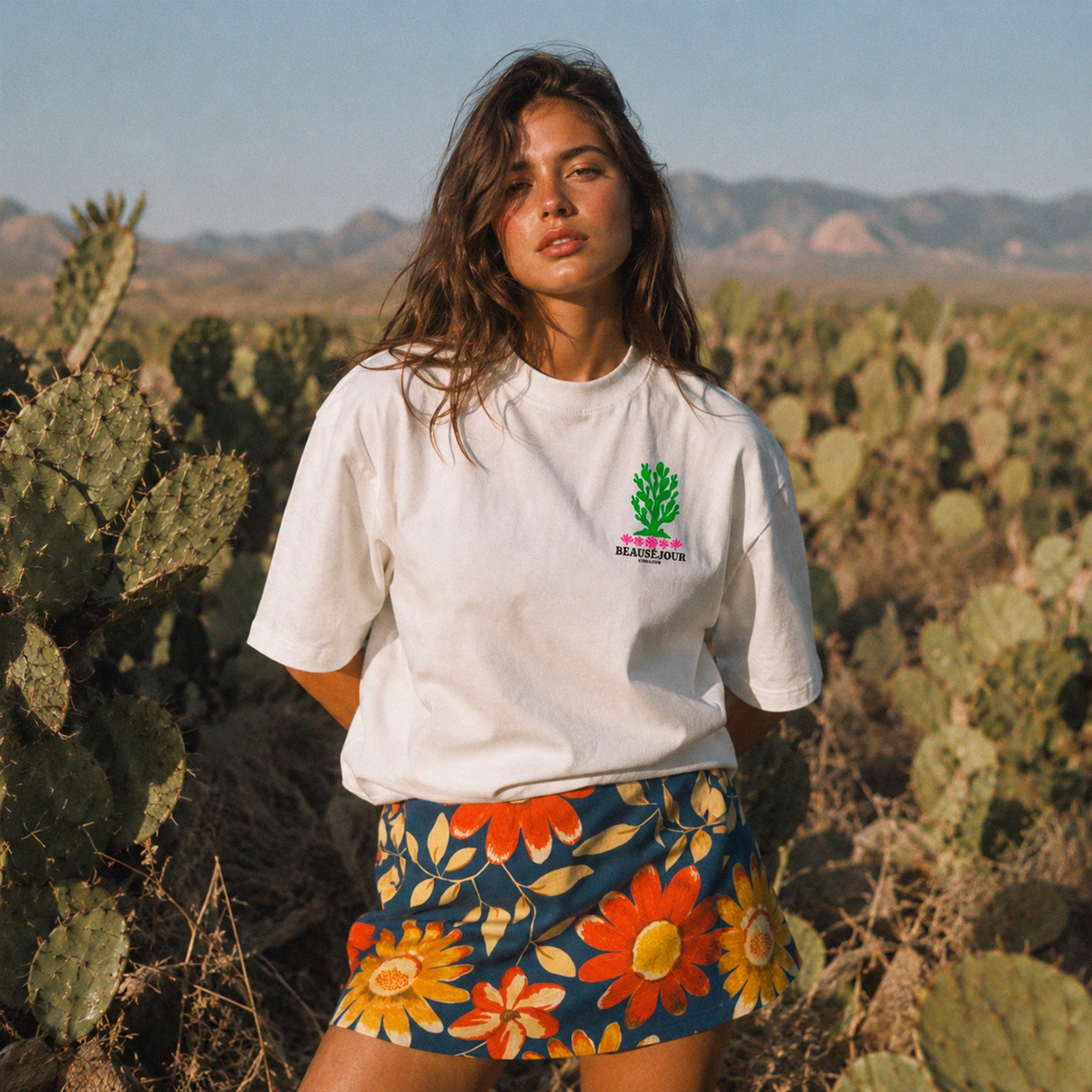 T-shirt boxy blanc Beauséjour Corazón en coton biologique, avec illustration cactus verte et fleurs roses inspirée du Mexique, petit logo poitrine et grand imprimé dans le dos.