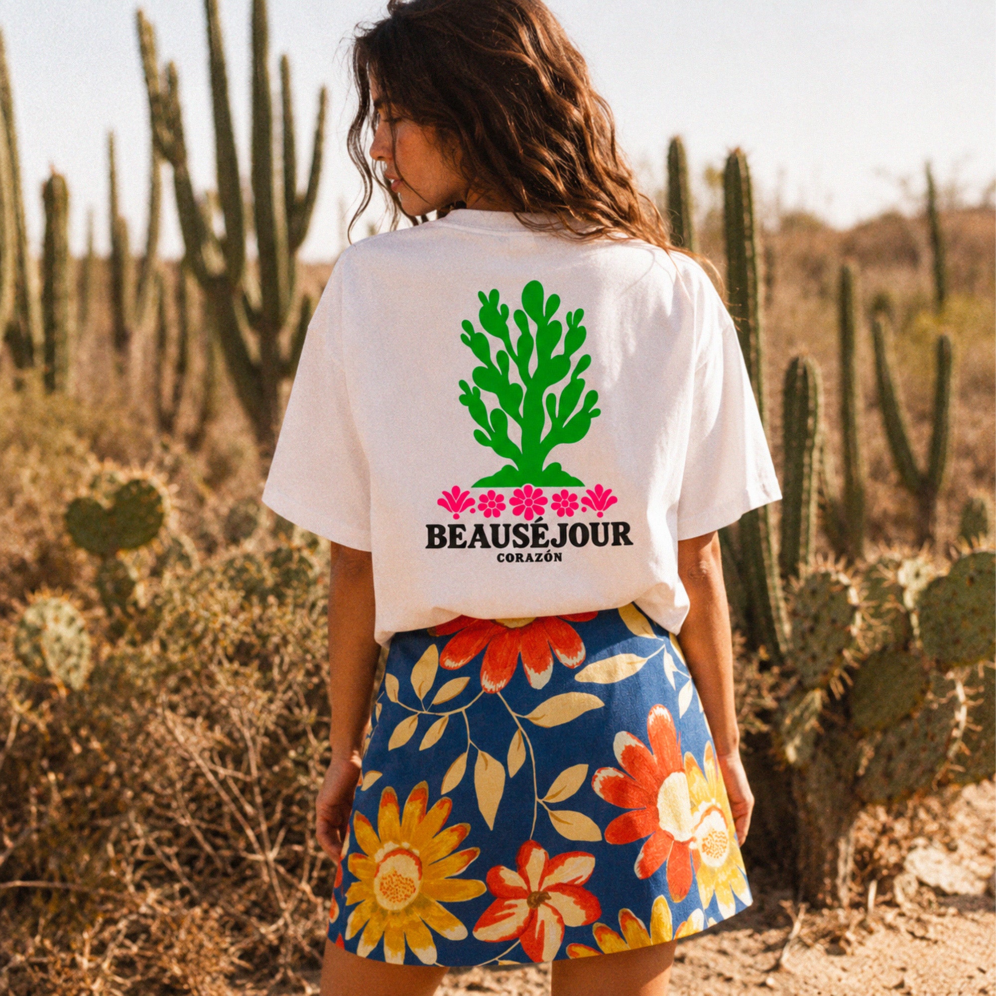 T-shirt boxy blanc Beauséjour Corazón en coton biologique, avec illustration cactus verte et fleurs roses inspirée du Mexique, petit logo poitrine et grand imprimé dans le dos.