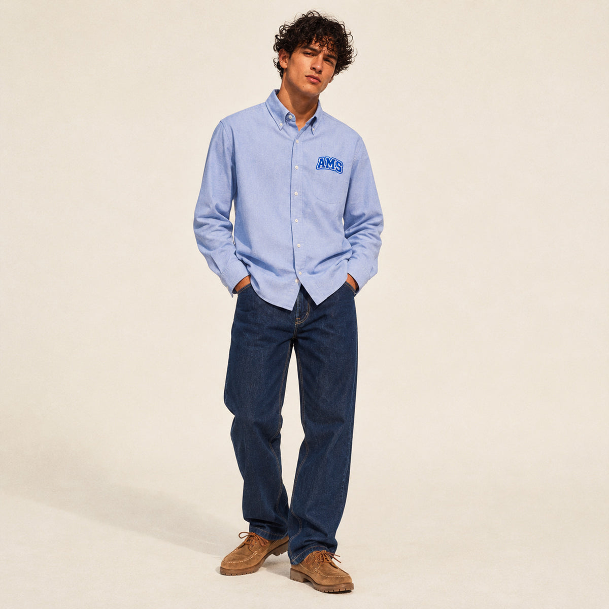 Chemise Oxford homme Beauséjour AMS bleu ciel en coton biologique, coupe élégante avec col classique, boutons blancs et patch AMS brodé sur la poitrine.