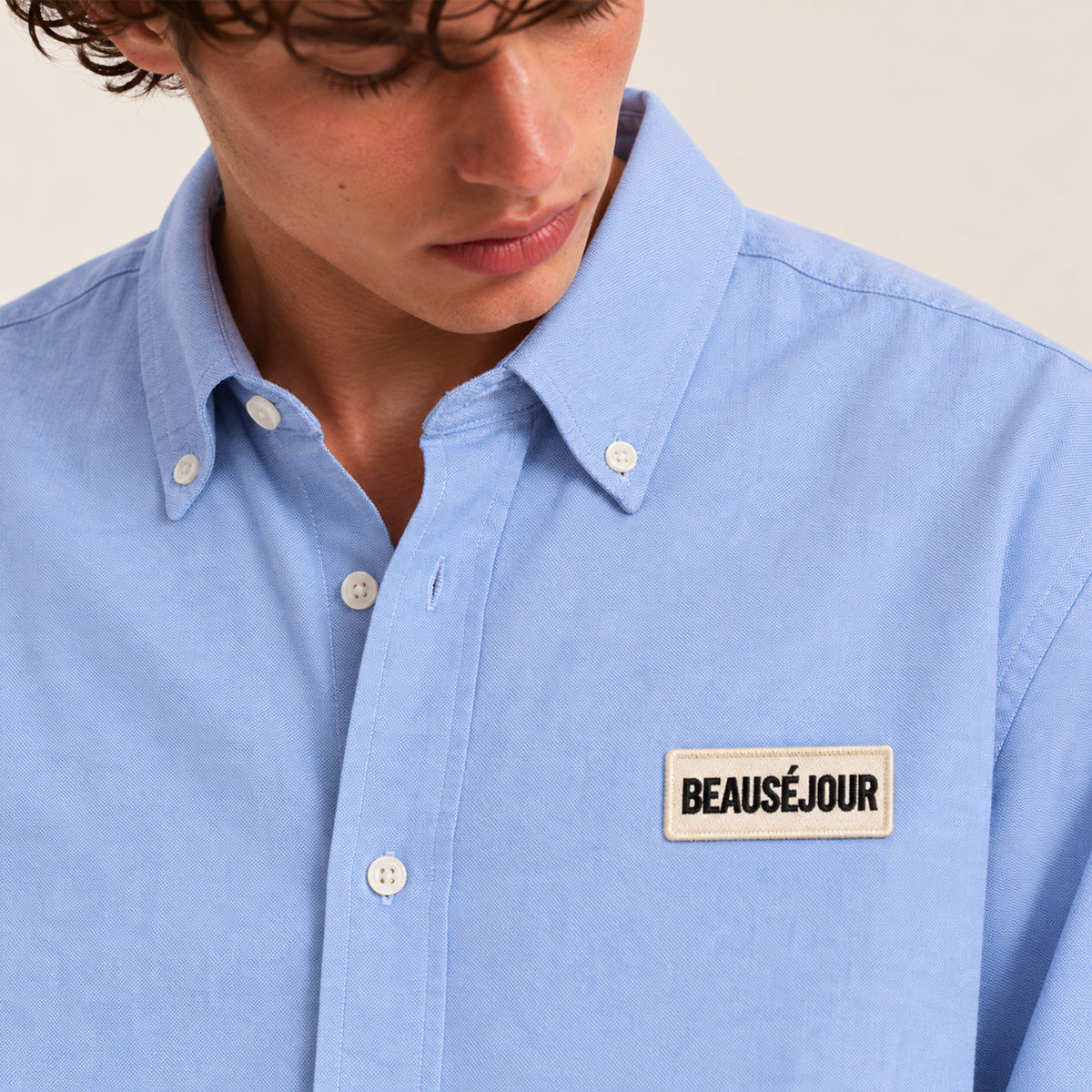 Chemise oxford bleu ciel pour homme. Patch beauséjour brodé thermocolée sur la poitrine. Zoom patch.