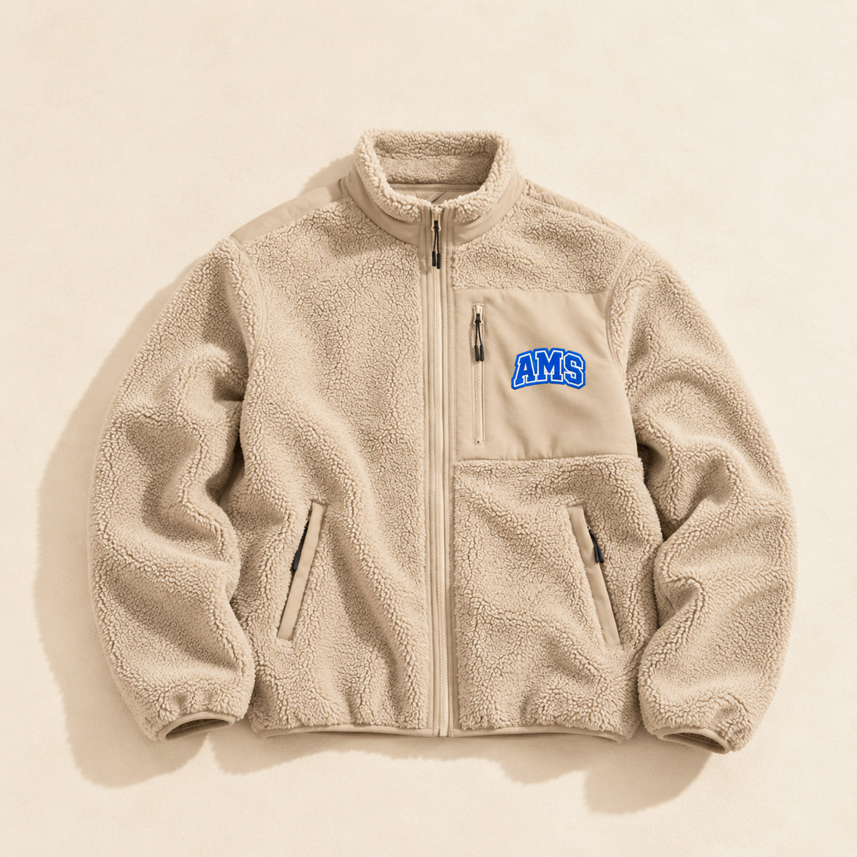 Polaire femme Beauséjour AMS bleu marine en Sherpa 450g recyclé, col montant zippé, empiècements softshell, poches zippées et patch AMS brodé sur la poitrine.