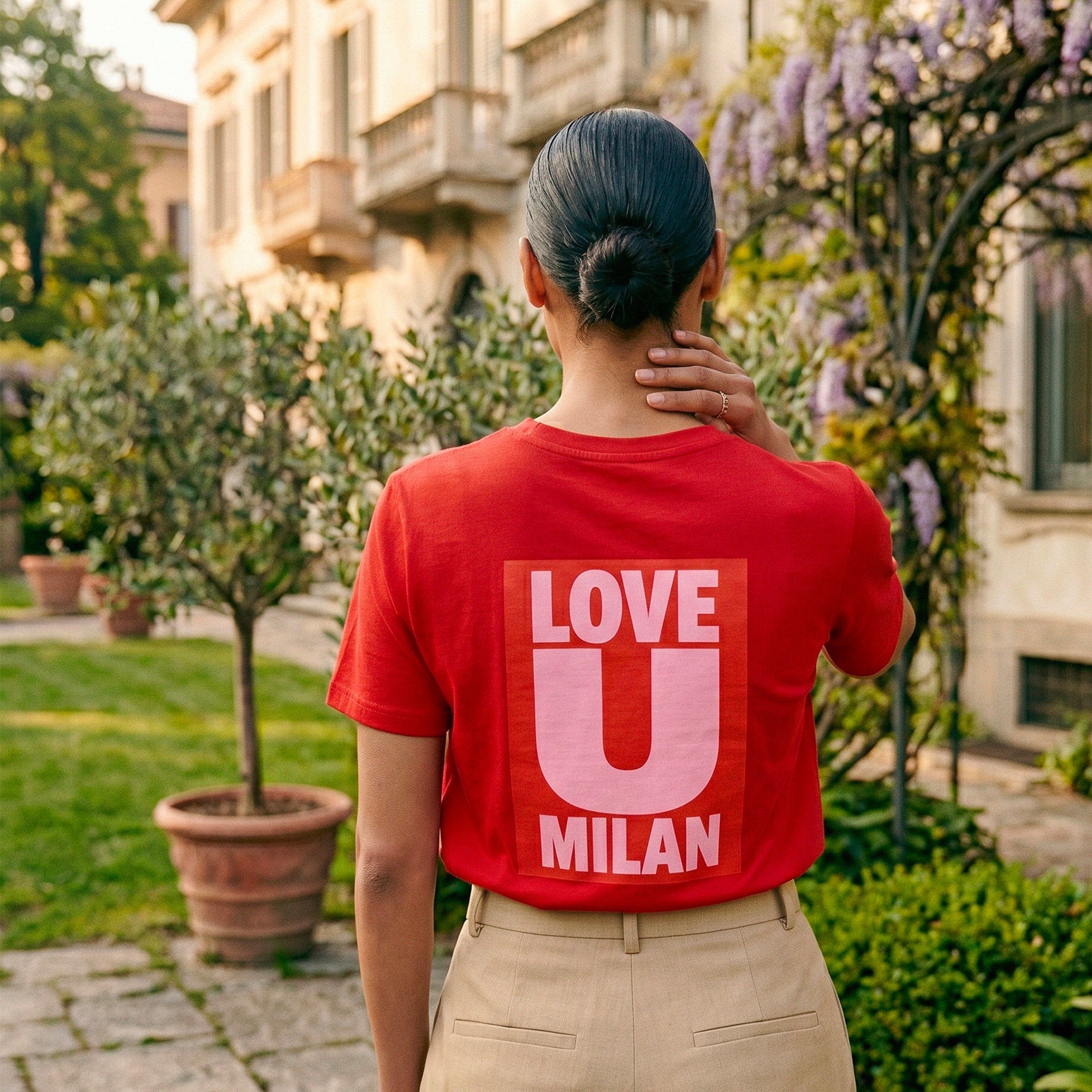 T-shirt rouge Beauséjour Milan "Love U Milan", imprimé graphique blanc au dos, coupe moderne femme, style casual chic inspiré de l’Italie, porté en extérieur.