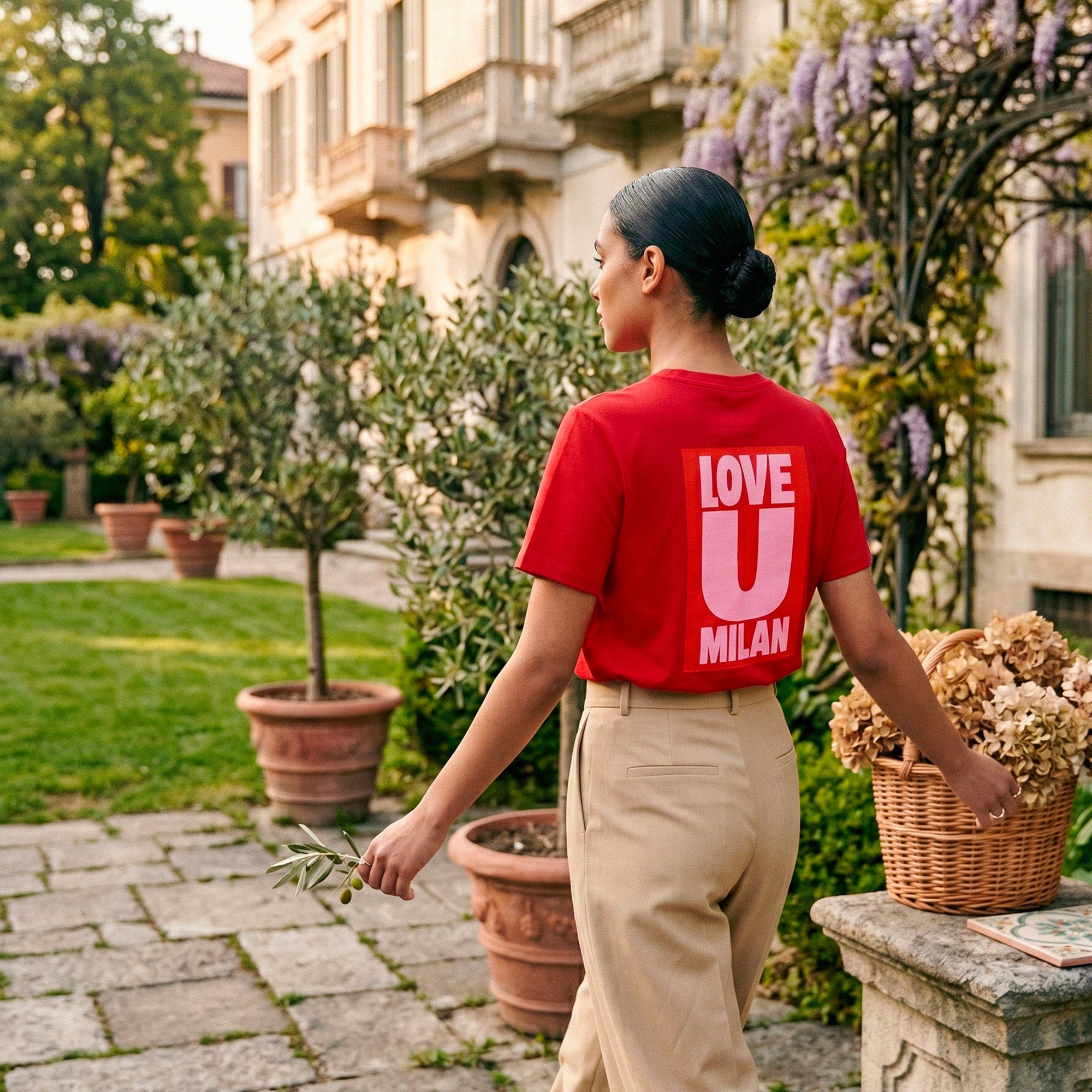 T-shirt rouge Beauséjour Milan "Love U Milan", imprimé graphique blanc au dos, coupe moderne femme, style casual chic inspiré de l’Italie, porté en extérieur.