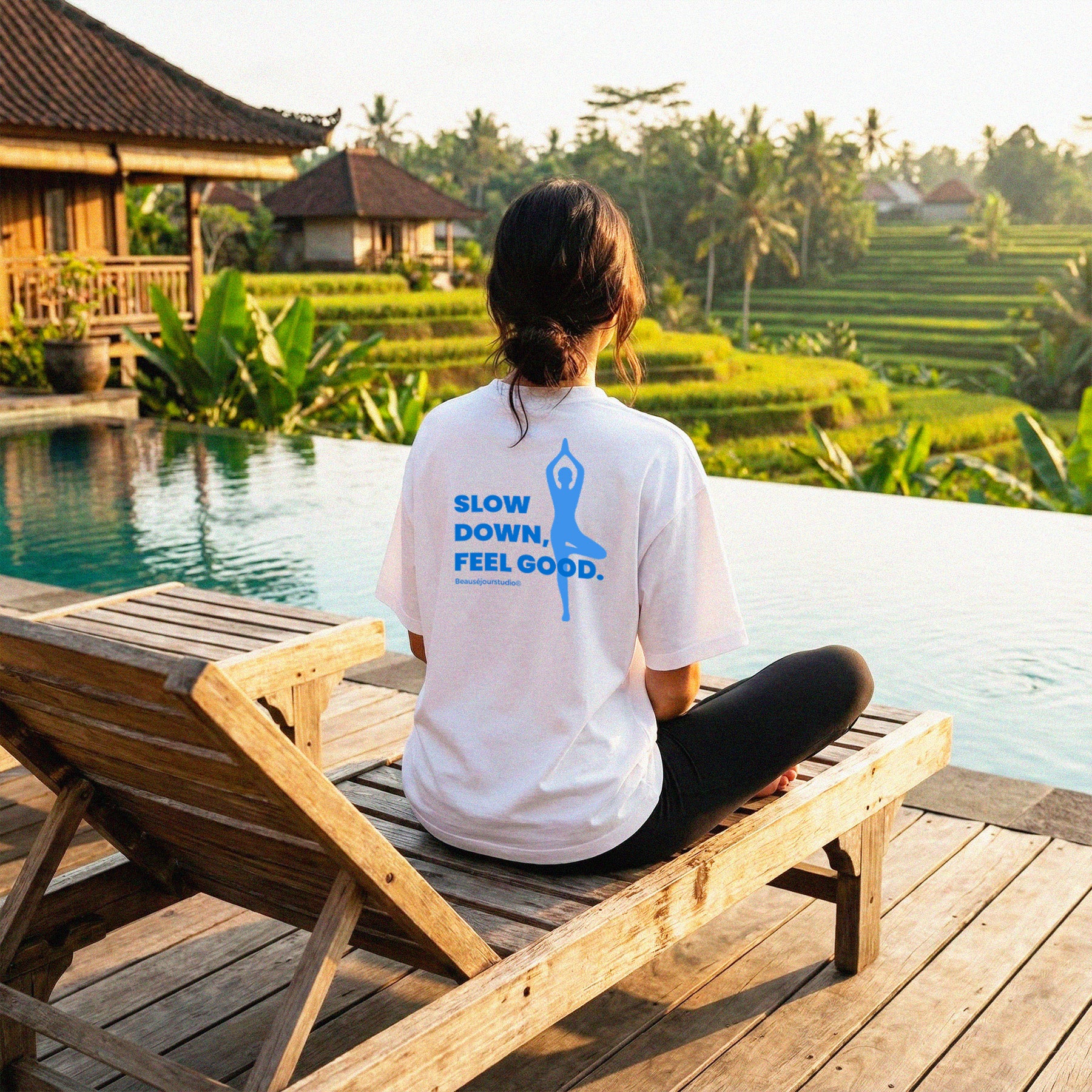 Femme dans un hotel a bali. Elle porte un tshirt imprimé "Slow Down Feel Good" couleur bleu. Tshirt 100% coton biologique beausejour france parfait pour les amoureux du yoga.