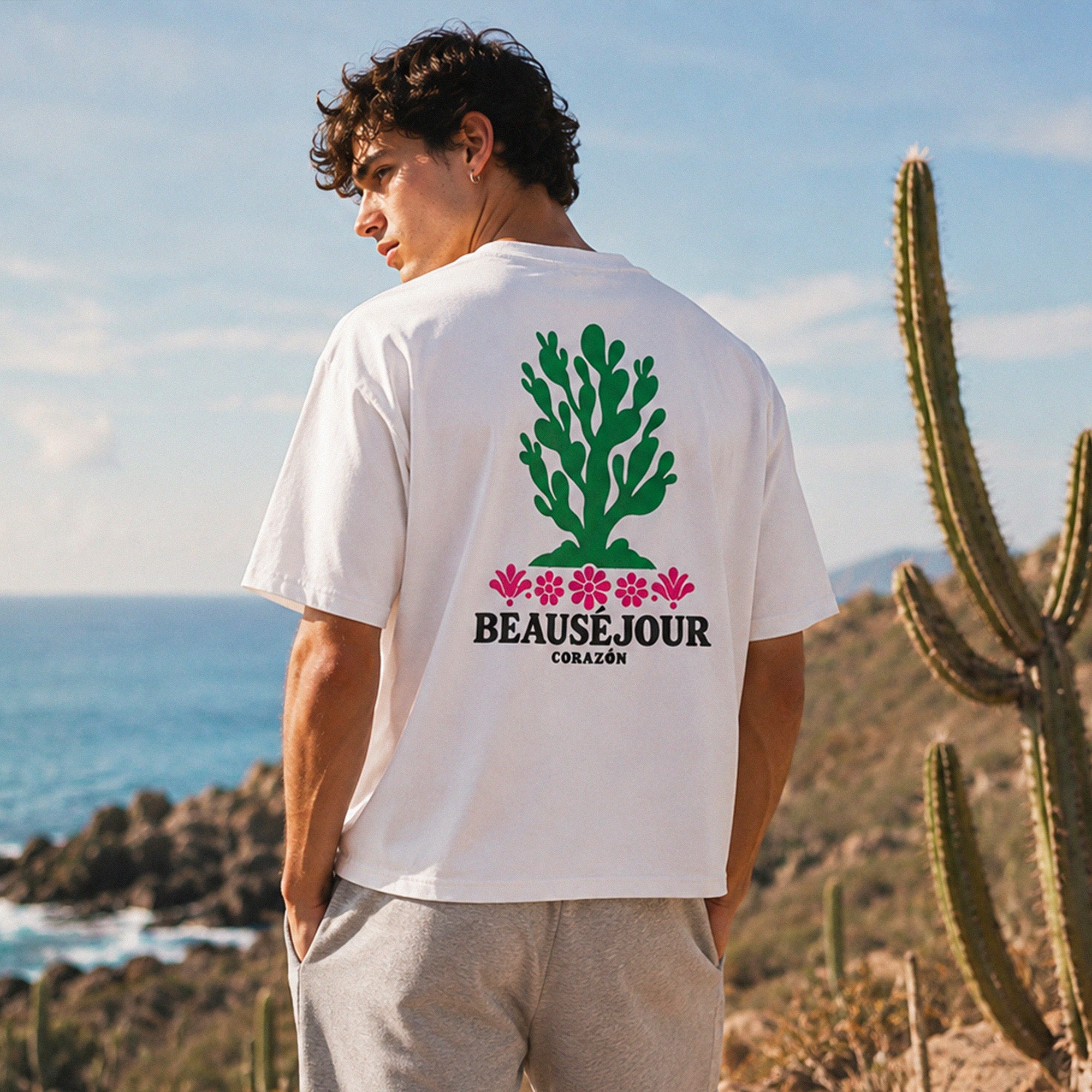 T-shirt boxy blanc Beauséjour Corazón en coton biologique, avec illustration cactus verte et fleurs roses inspirée du Mexique, petit logo poitrine et grand imprimé dans le dos.