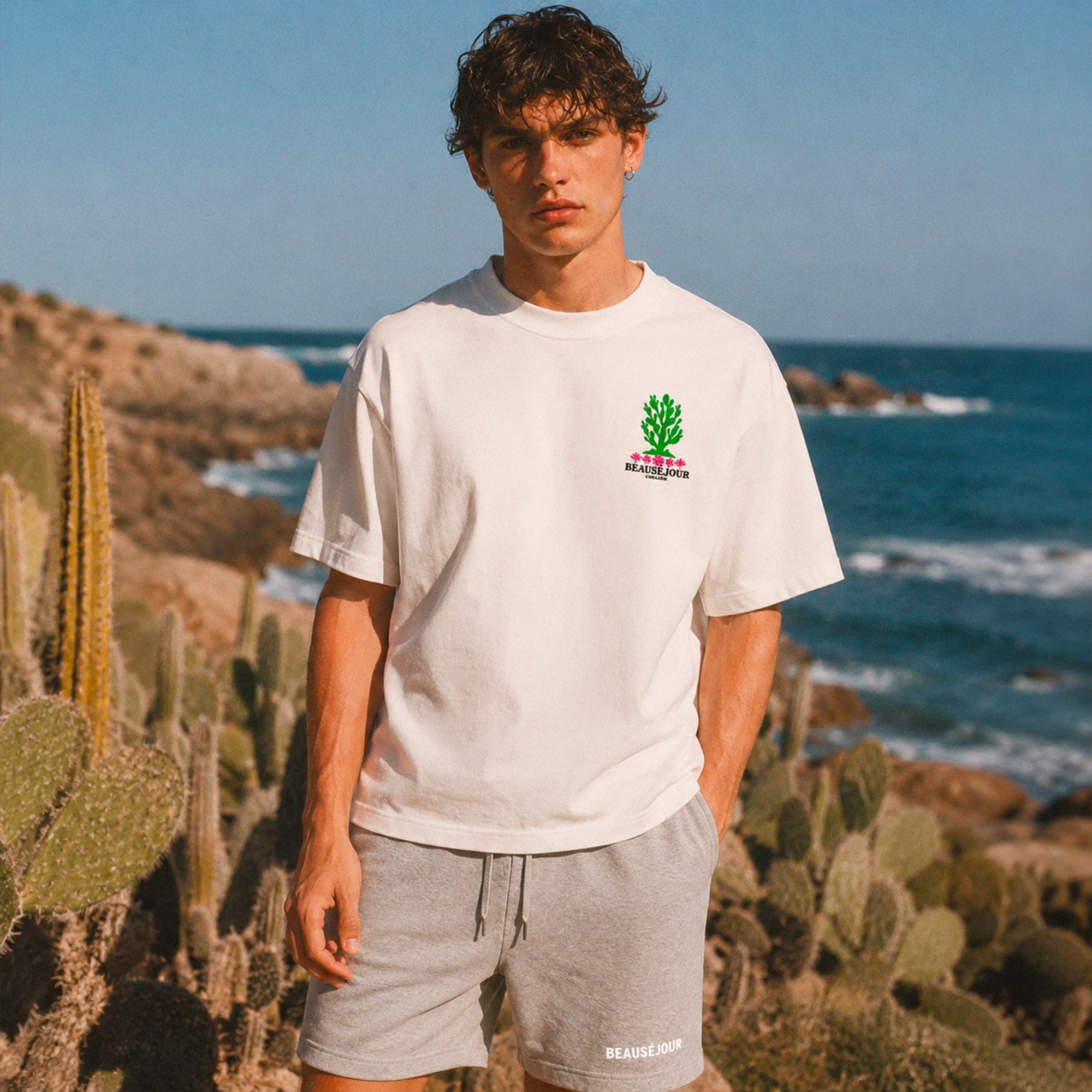 T-shirt boxy blanc Beauséjour Corazón en coton biologique, avec illustration cactus verte et fleurs roses inspirée du Mexique, petit logo poitrine et grand imprimé dans le dos.