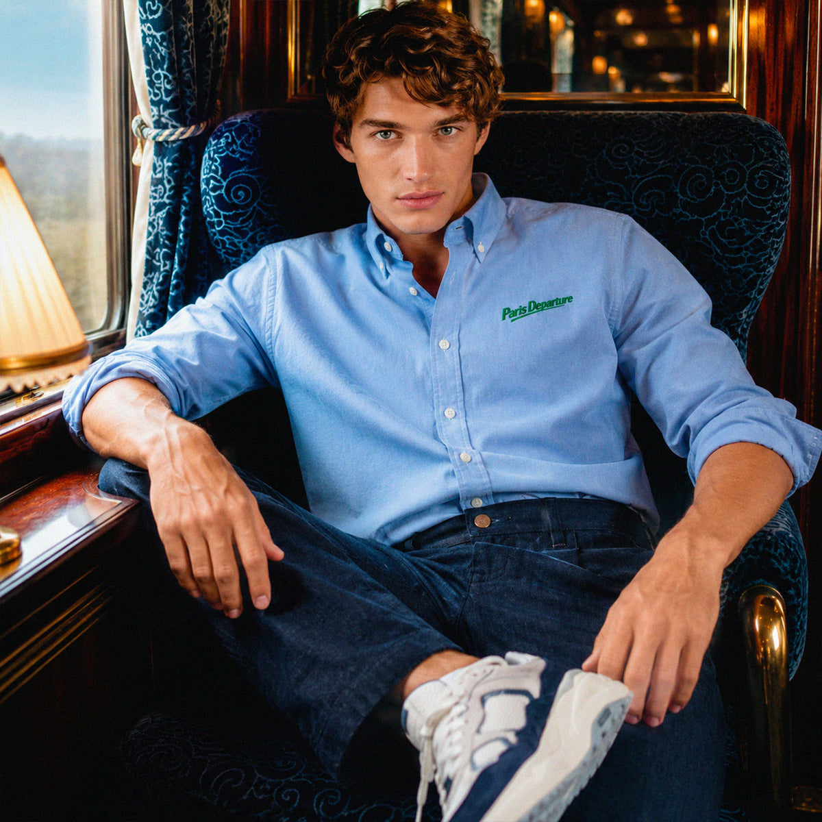 Chemise Oxford Paris Departure Beauséjour Orient Express, coloris bleu Oxford, 100% coton biologique Oxford, broderie Paris Departure verte côté cœur inspirée des uniformes de voyage anciens, vue de face.