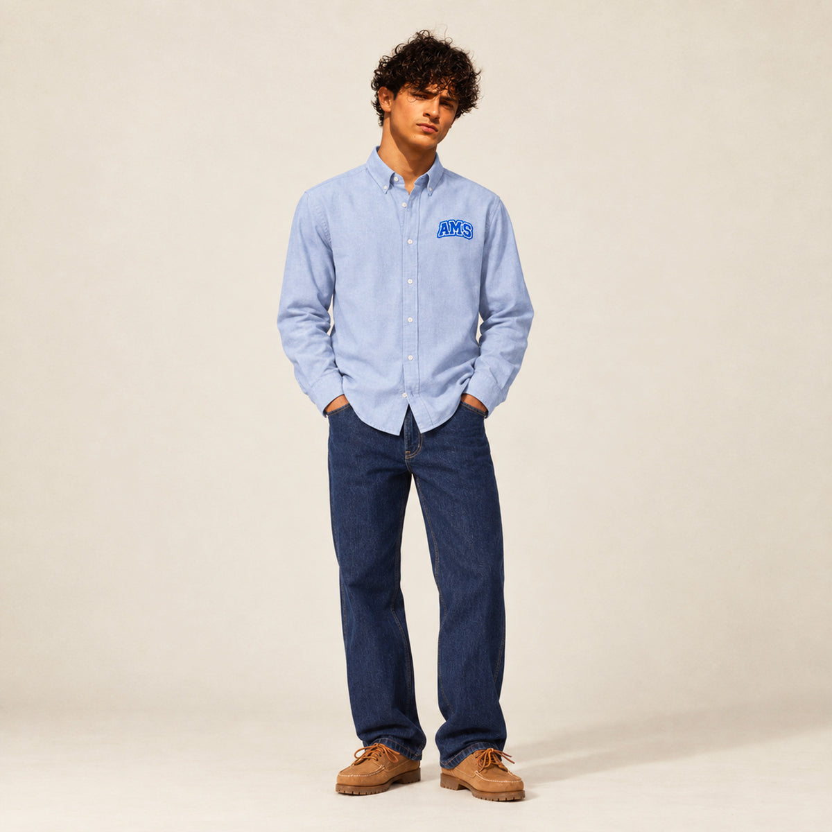 Chemise Oxford homme Beauséjour AMS bleu ciel en coton biologique, coupe élégante avec col classique, boutons blancs et patch AMS brodé sur la poitrine.