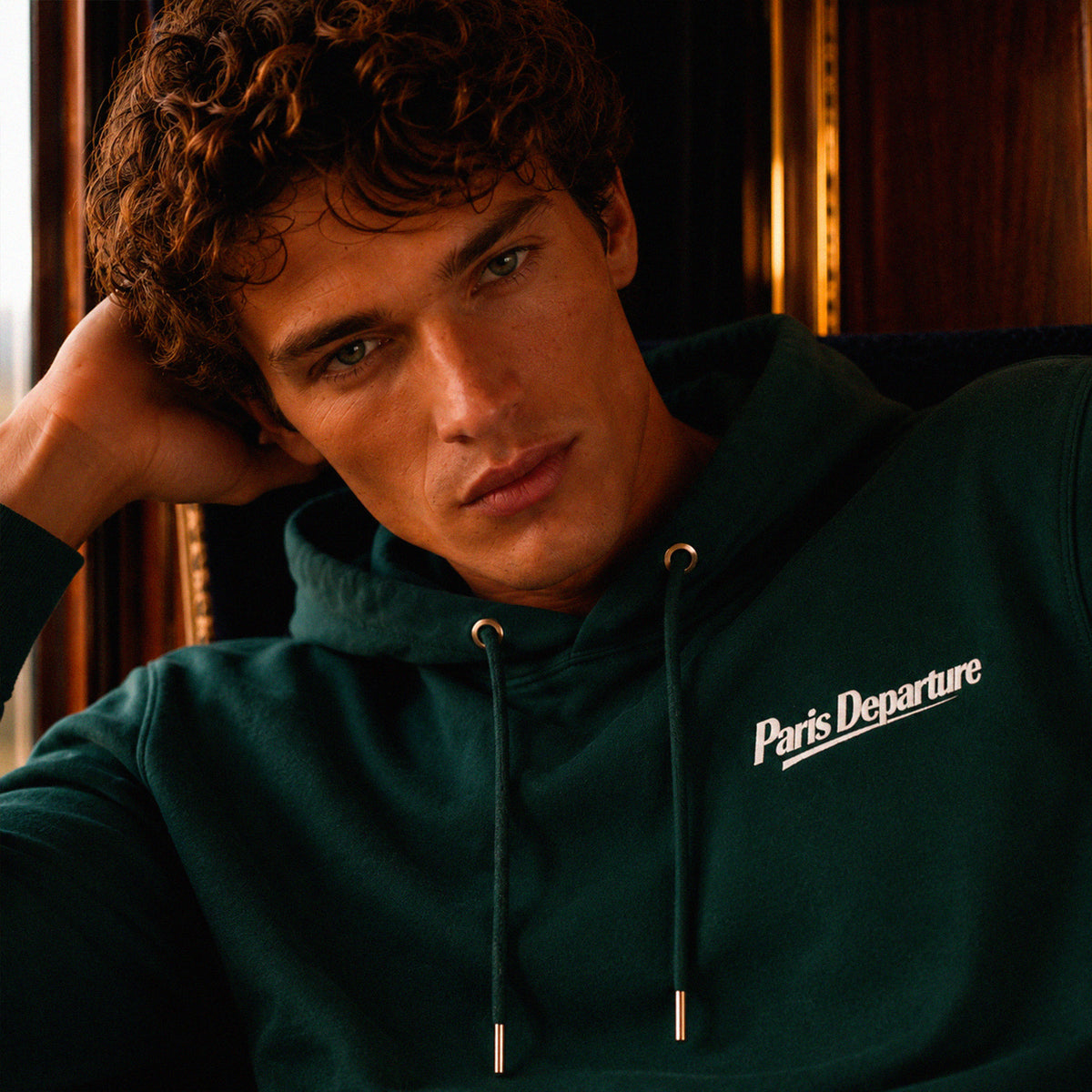 Hoodie Paris Departure Beauséjour Orient Express, coloris vert Glazed Green, 100% coton biologique molleton brossé, imprimé Paris Departure côté cœur et marquage dos inspiré des compagnies de voyage anciennes, détail de la capuche et du col.