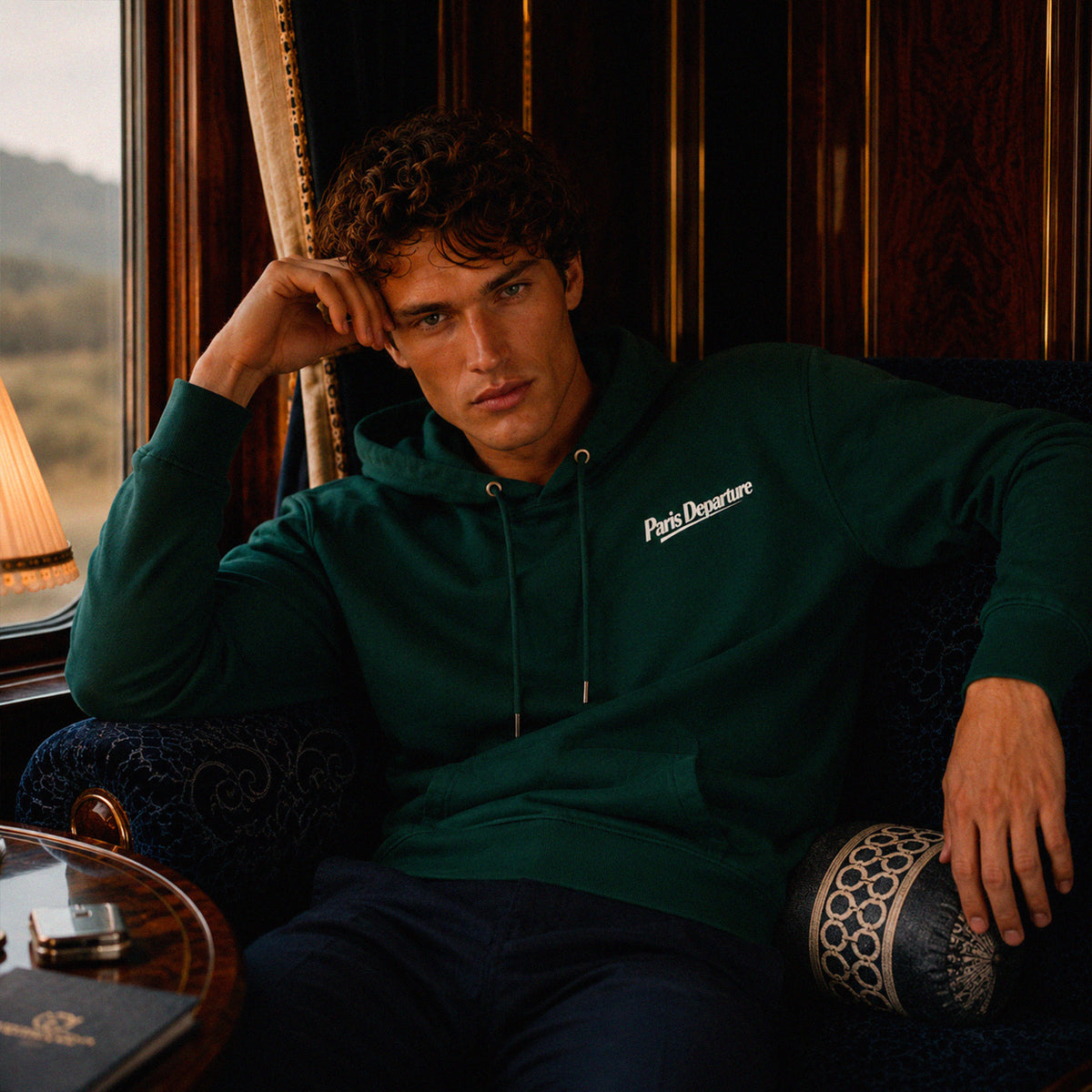 Hoodie Paris Departure Beauséjour Orient Express, coloris vert Glazed Green, 100% coton biologique molleton brossé, imprimé Paris Departure côté cœur et marquage dos inspiré des compagnies de voyage anciennes, look complet.