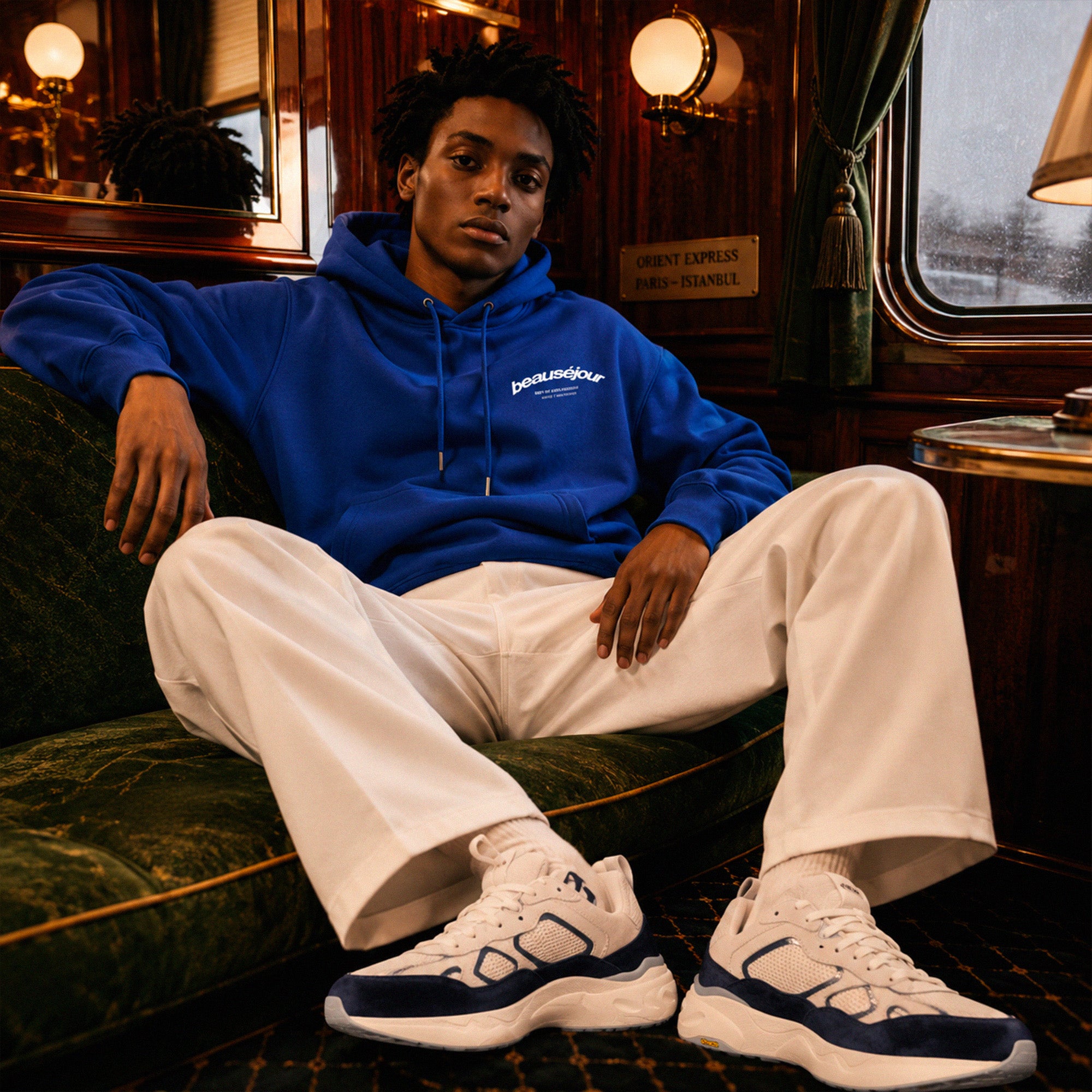 Hoodie Room 27 Venice Beauséjour Orient Express, coloris bleu royal, logo poitrine minimaliste et grand imprimé dos "Beauséjour — Meet Me After Midnight — Room 27 Venice Stopover", capuche ajustable et poche kangourou, détail de la capuche.