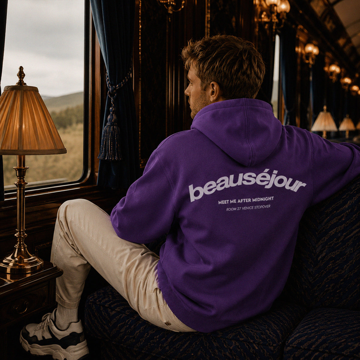 Hoodie Room 27 Venice Beauséjour Orient Express, coloris violet profond, logo poitrine minimaliste et grand imprimé dos "Beauséjour — Meet Me After Midnight — Room 27 Venice Stopover", capuche ajustable et poche kangourou, détail de la capuche.
