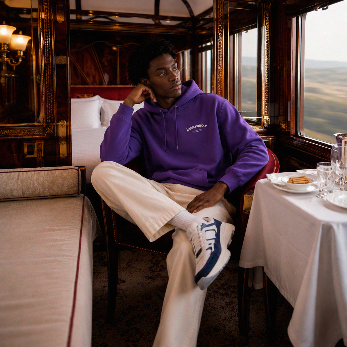 Hoodie Room 27 Venice Beauséjour Orient Express, coloris violet profond, logo poitrine minimaliste et grand imprimé dos "Beauséjour — Meet Me After Midnight — Room 27 Venice Stopover", capuche ajustable et poche kangourou, vue de face.