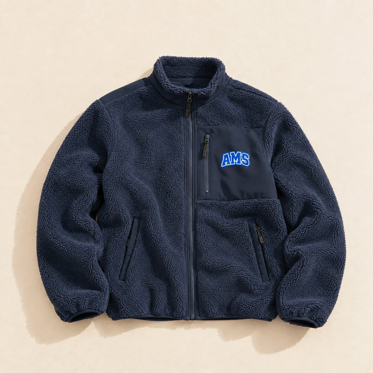Polaire homme Beauséjour AMS bleu marine en Sherpa 450g recyclé, col montant zippé, empiècements softshell, poches zippées et patch AMS brodé sur la poitrine.