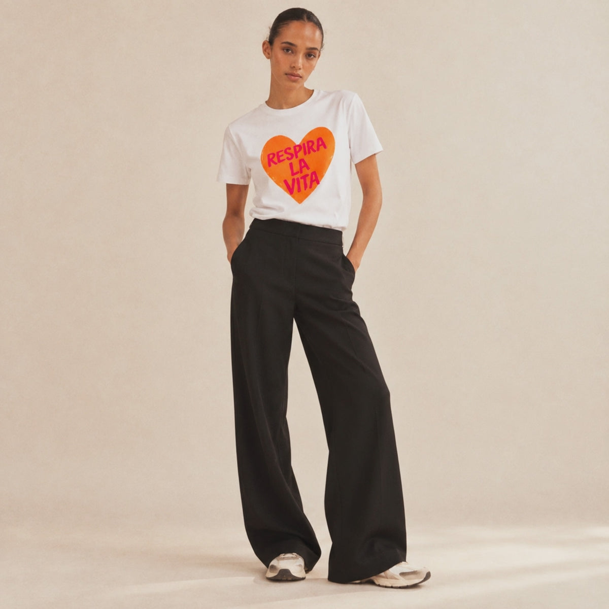 Film Femme portant un t-shirt blanc Respira la Vita Beauséjour, imprimé orange.