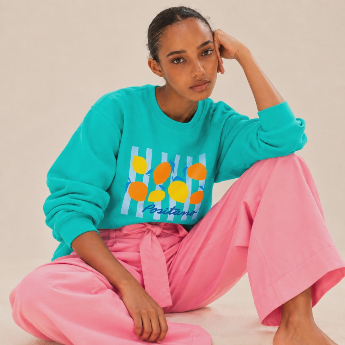 Film Femme portant un sweat col rond Positano turquoise avec motif citrons, Beauséjour. Coton bio.