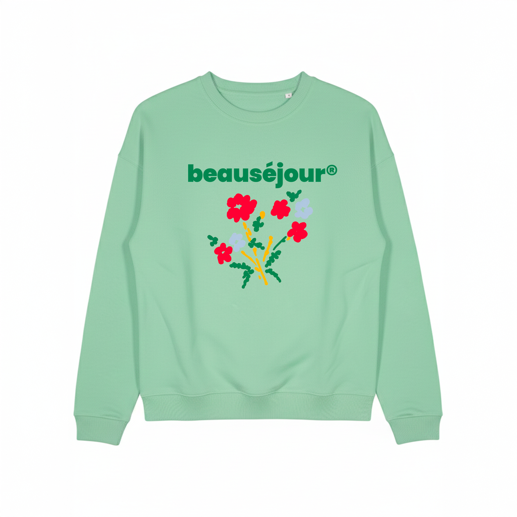 Femme portant un sweatshirt lifestyle Beausejour vert à motif floral sur la plage, marque française de vêtements lifestyle, sweat et t-shirt casual inspirés de l’été.
